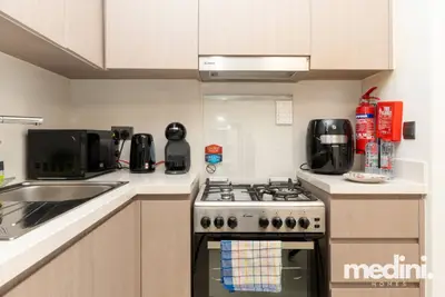 Kitchen counter with a gas stove, microwave, and capsule coffee machine