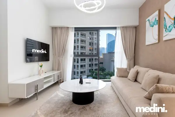 Bright living room with beige sofa, marble coffee table, and city views