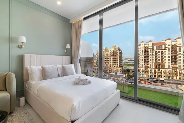 Bedroom with a large window overlooking ornate residential buildings