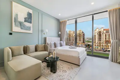 Bedroom with sage-green walls, double bed, and city view through glass doors