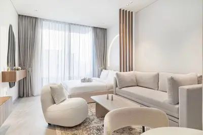 Open studio space with sofa, accent chair, coffee table, and arched wood divider