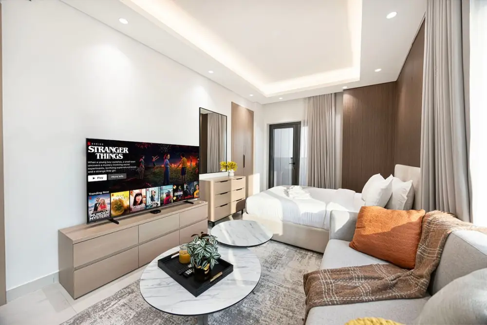 Studio open plan with sofa, marble coffee table, and flat-screen TV on a sideboard