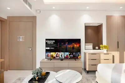 TV area with low wooden sideboard, dresser with mirror, and warm recessed lighting