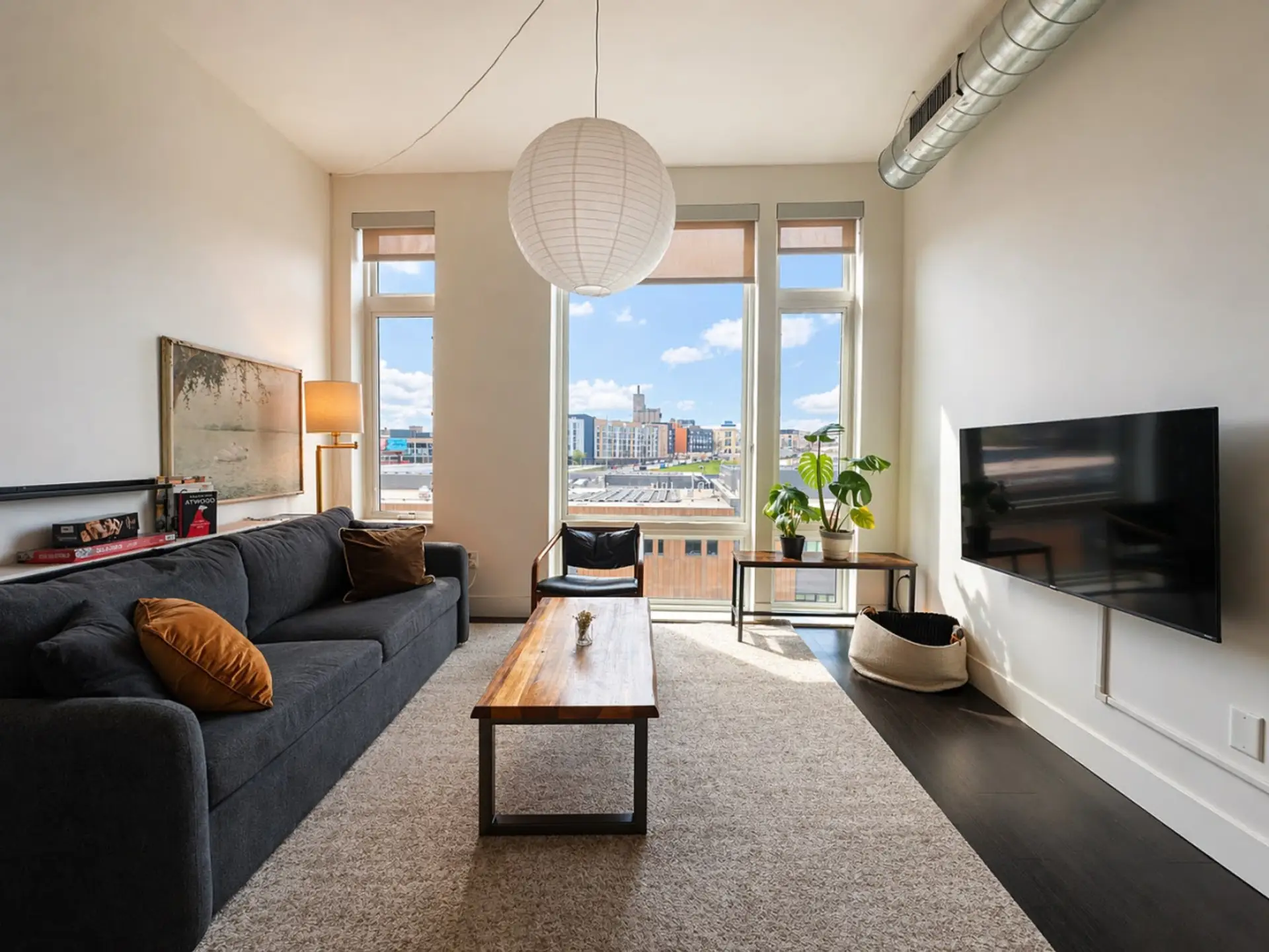 Kick back and relax in the modern living space, featuring flexible seating, abundant natural light, and sweeping city views