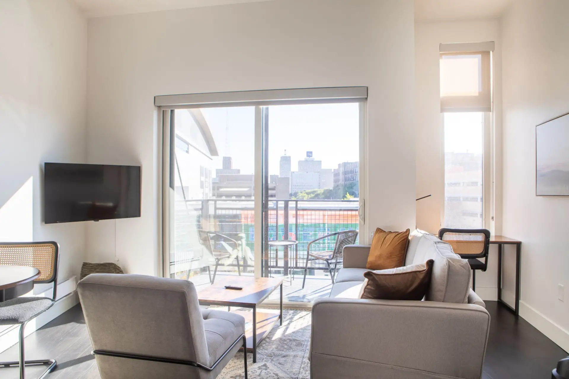 Kick back and relax in the modern living space, featuring a private balcony, flexible seating, and a smart TV with built-in Airplay