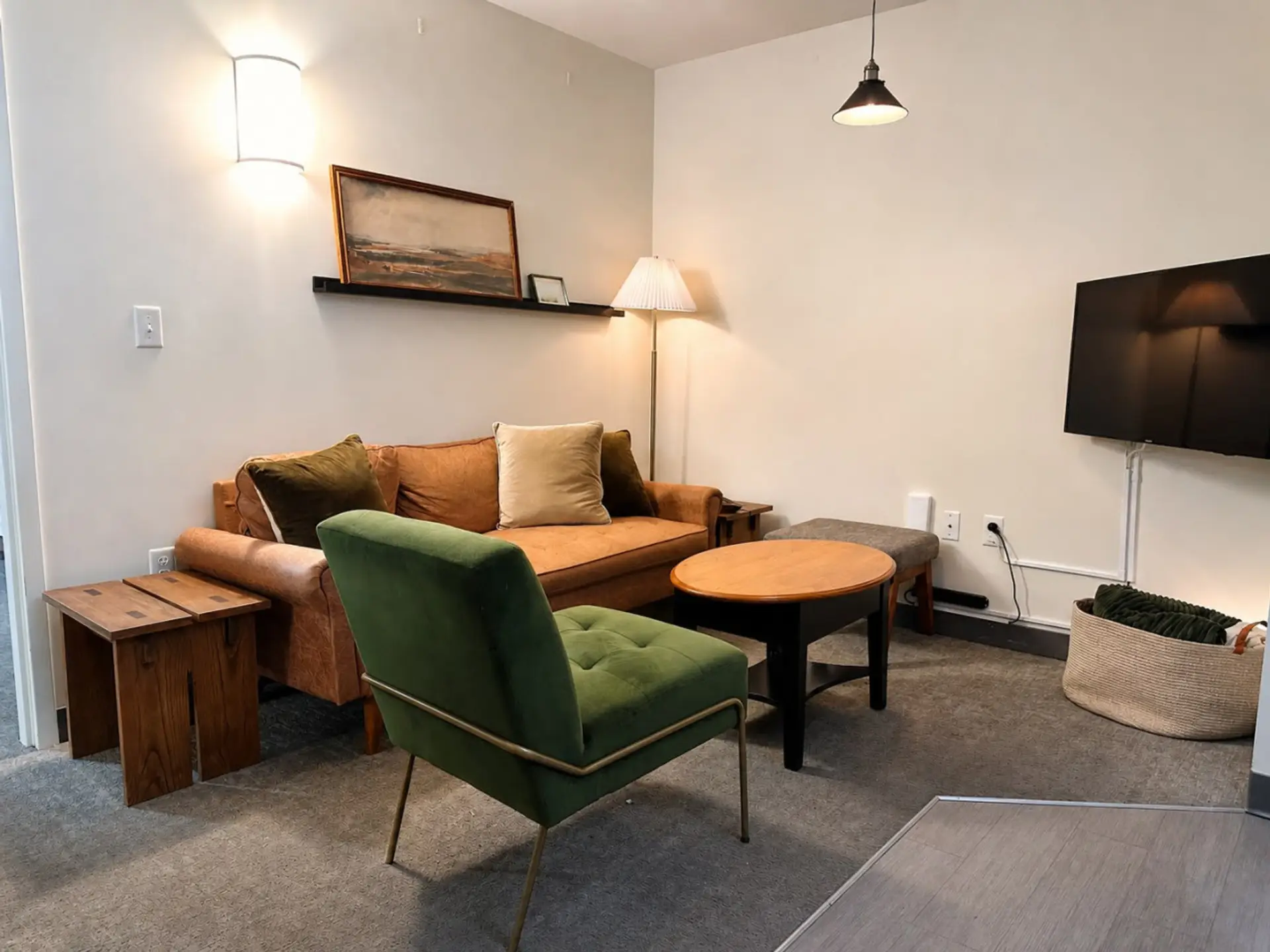 Relax in the open-concept living area featuring soaring industrial ceilings, plush seating, and a versatile dining table/workspace