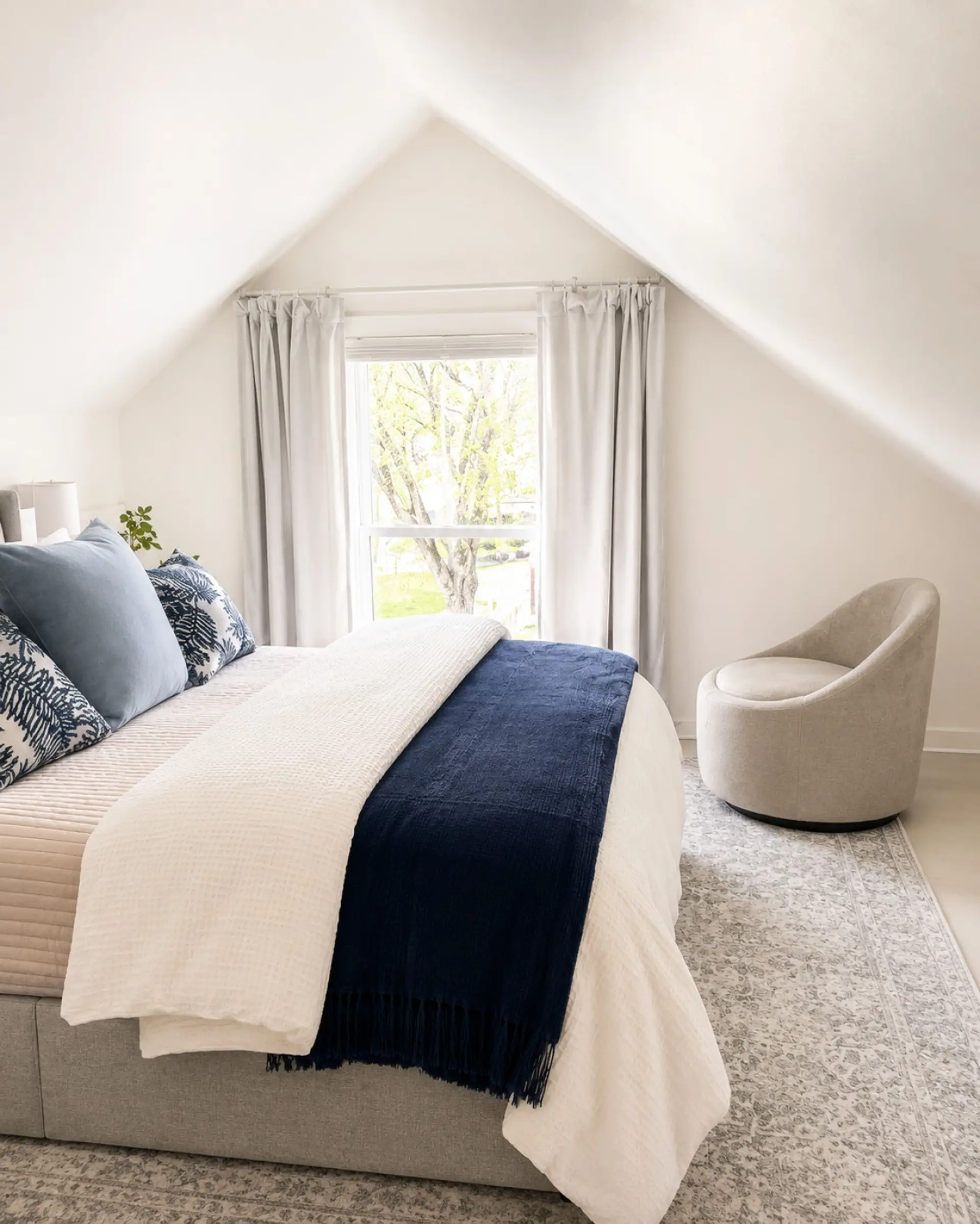 The Attic queen bed has a full dresser and nightstands on each side, with a window over looking the side yard and view of the college. Side chair for reading