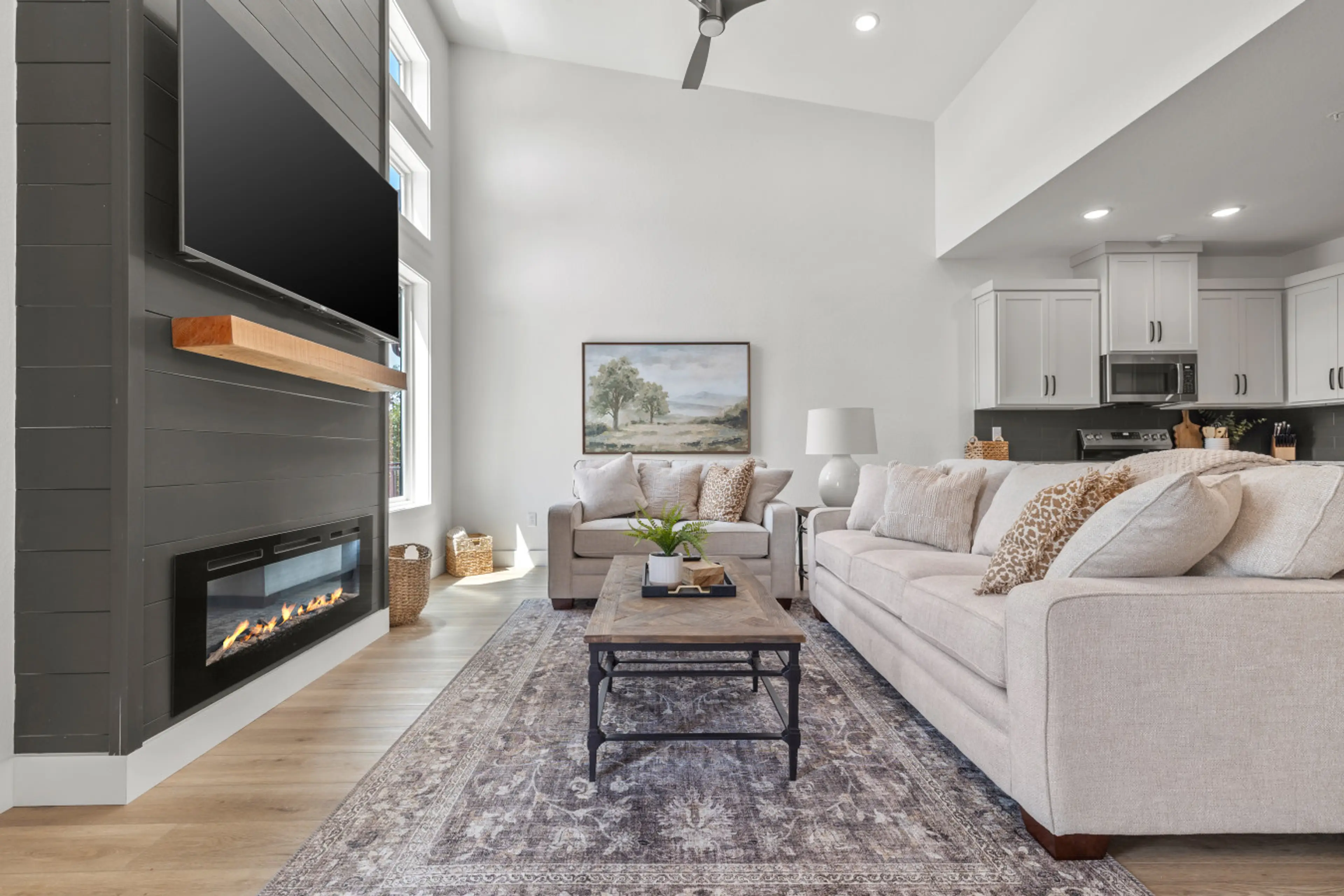 Spacious living room with vaulted ceilings, cozy fireplace, and plenty of natural light.