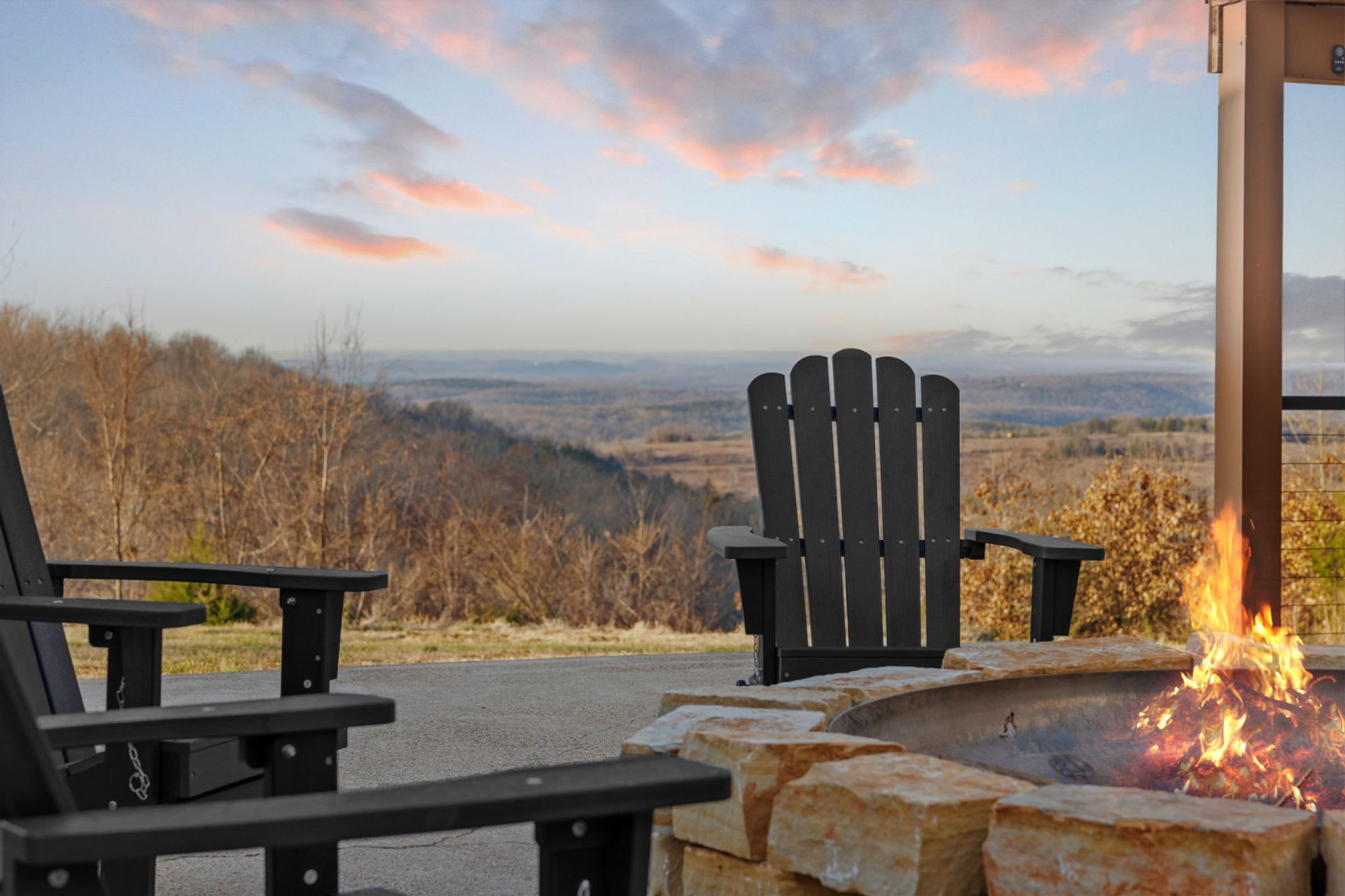 Fire pit and Adirondack chairs above the Ozark hills at dusk