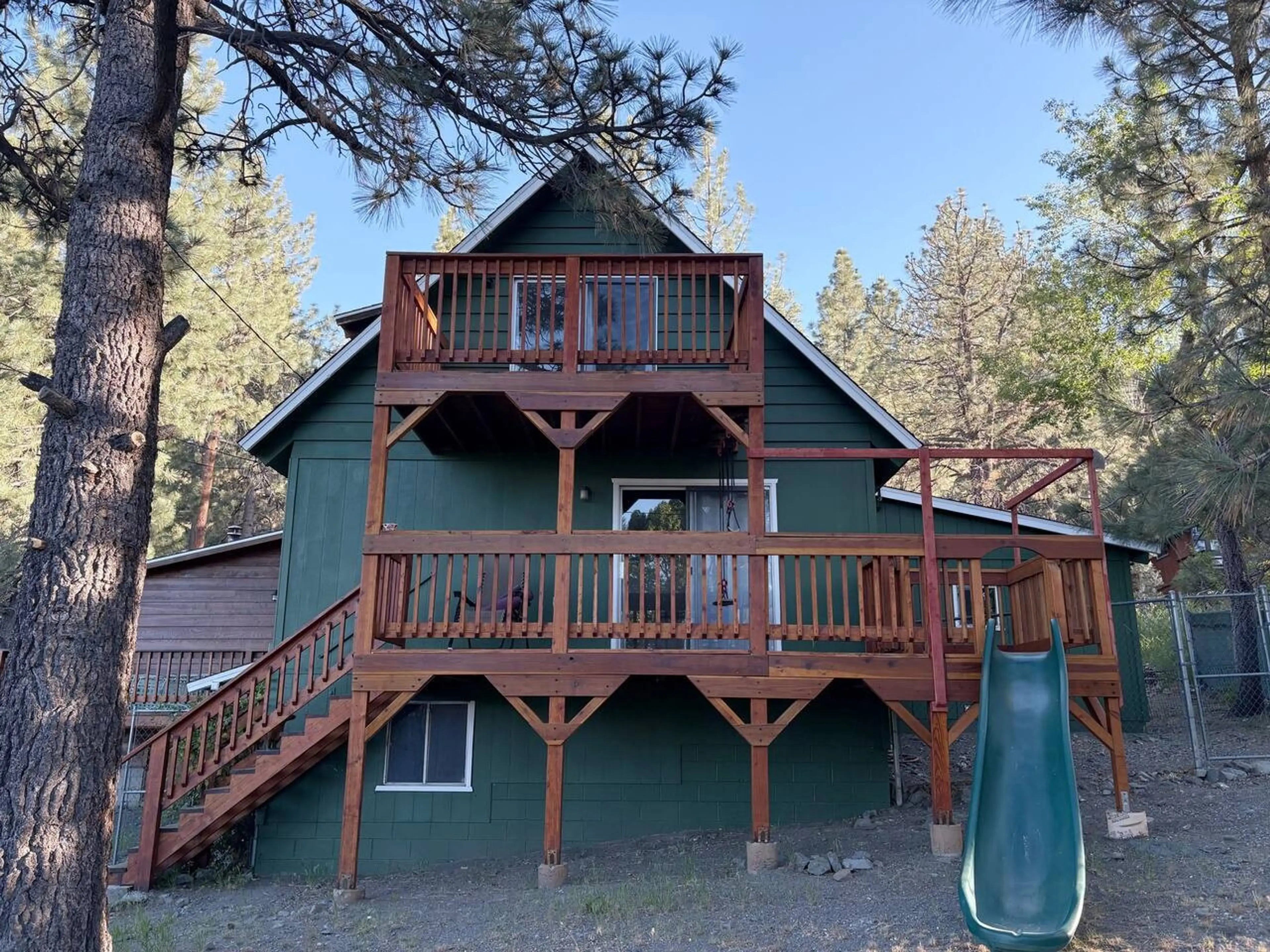 A cozy mountain retreat nestled among the pines! ✨  Wake up to pine trees, sip coffee on the deck, slide down the hill like you’re 10 again (yes, there’s a slide), and just exist in peace for a bit. 💚