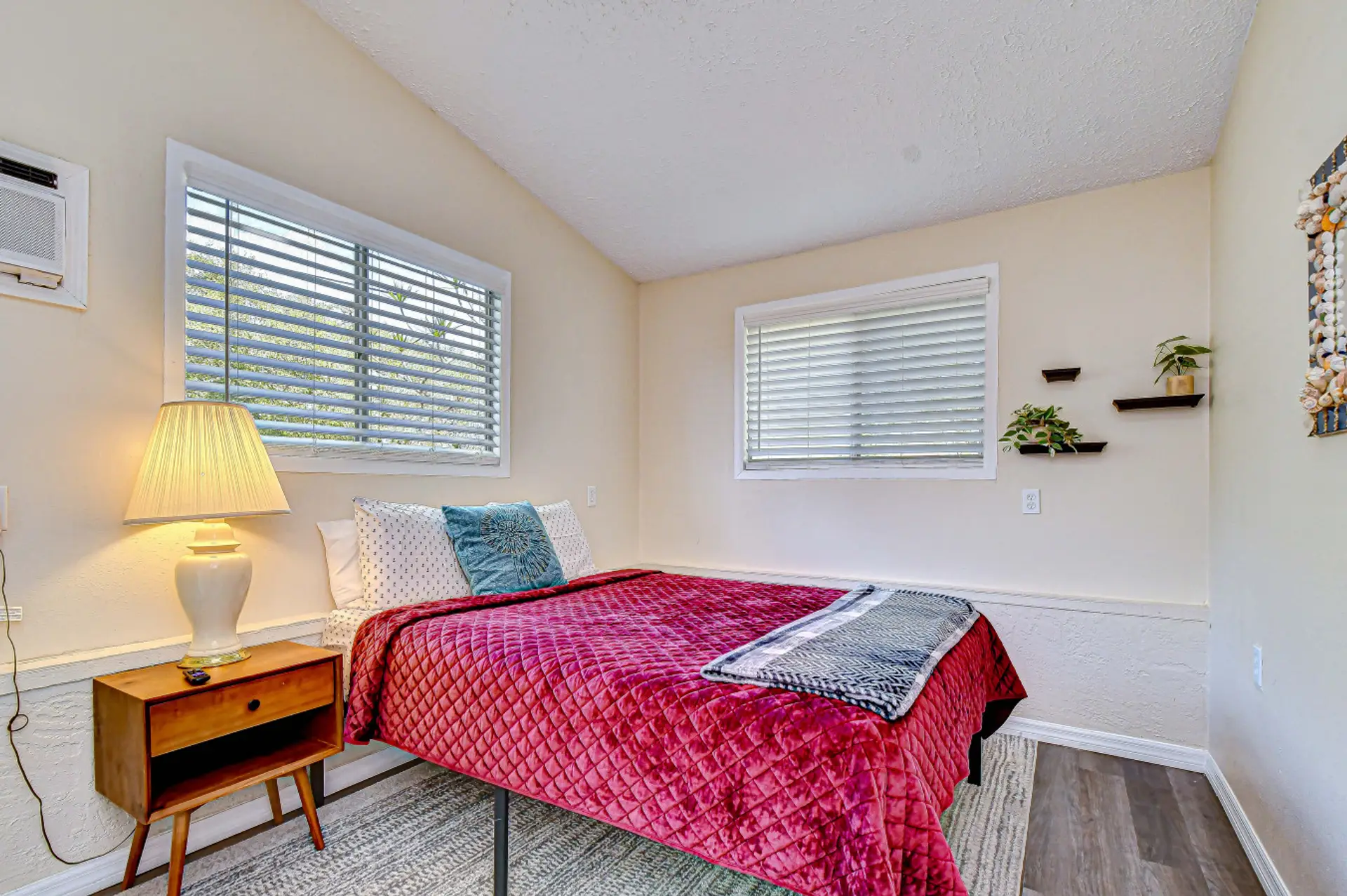 The bedroom features a queen bed, smart tv, end table and large closet