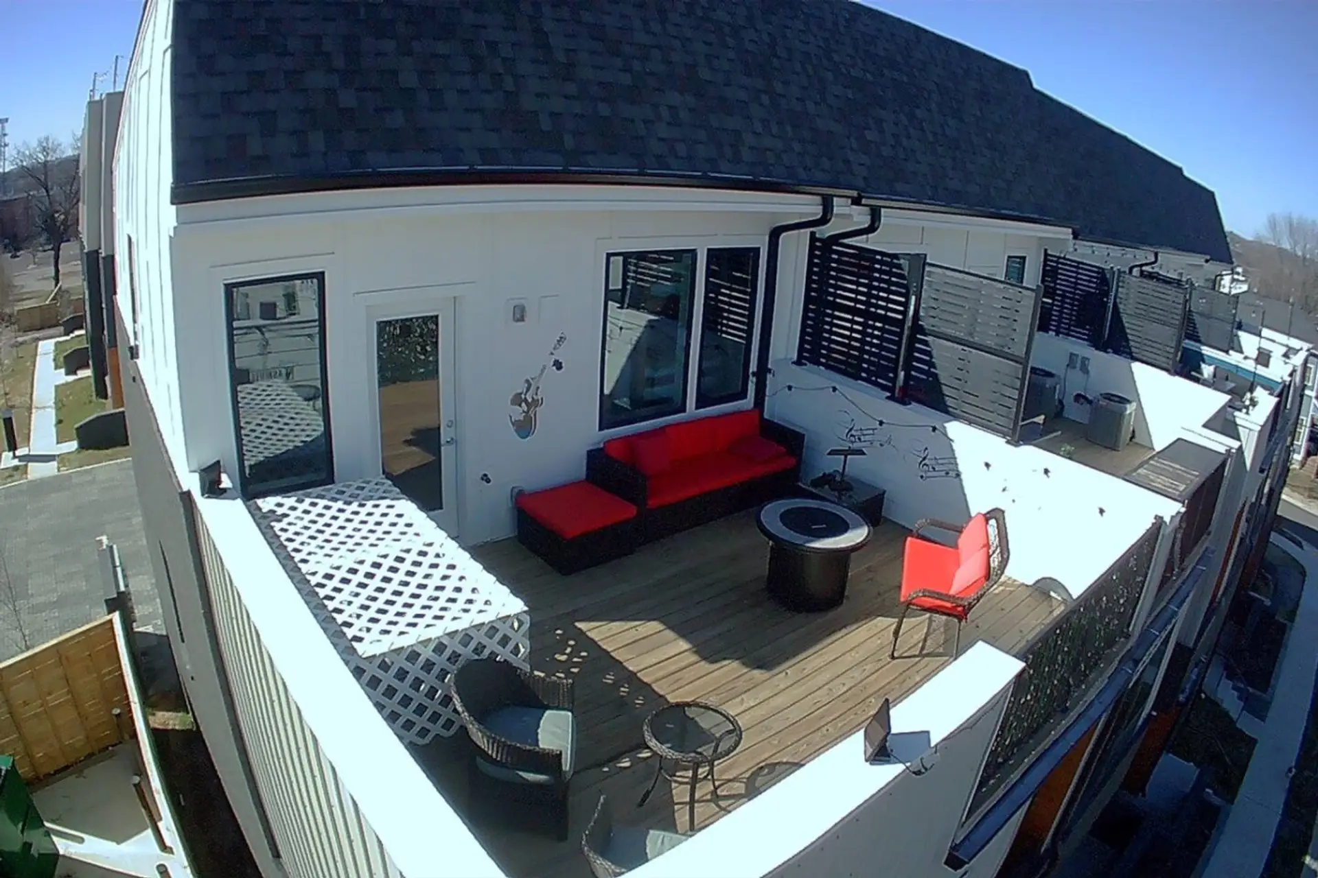 Rooftop deck aerial view with outdoor sofas, tables, and city views