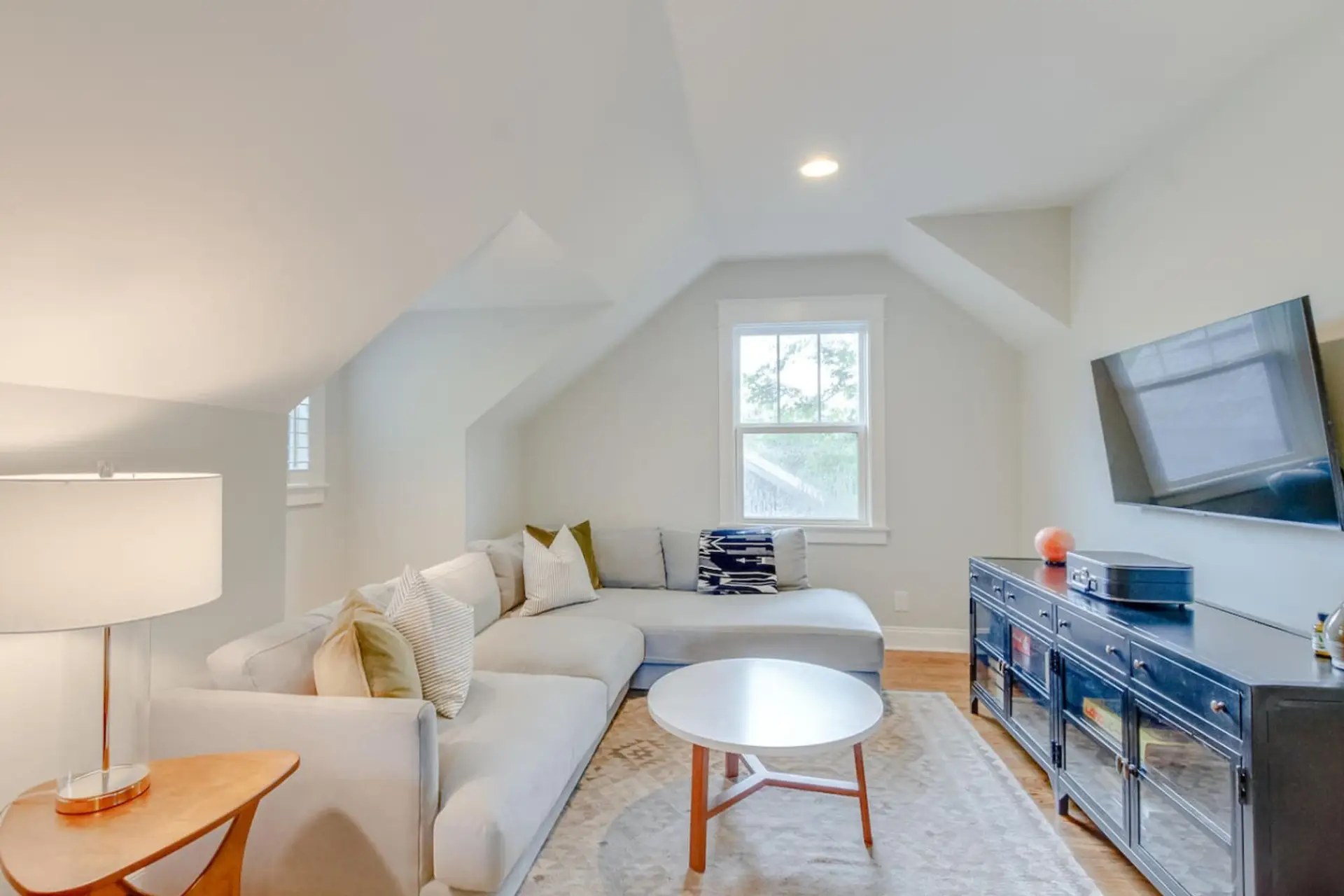 Comfortable living room with a sectional sofa, mounted smart TV, and round coffee table