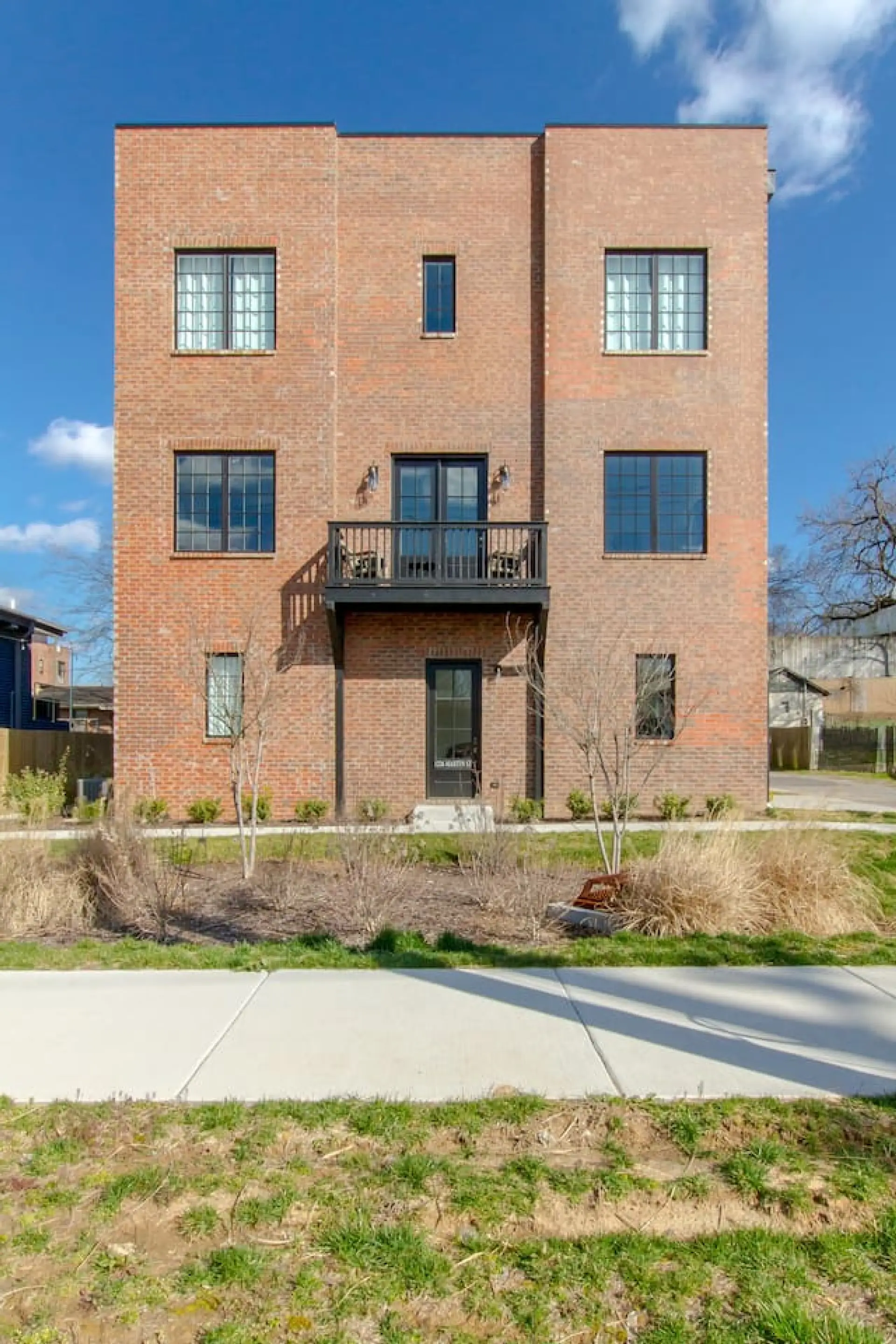 The brick exterior with a balcony and large windows gives this Martin Street townhouse a bold, modern look.