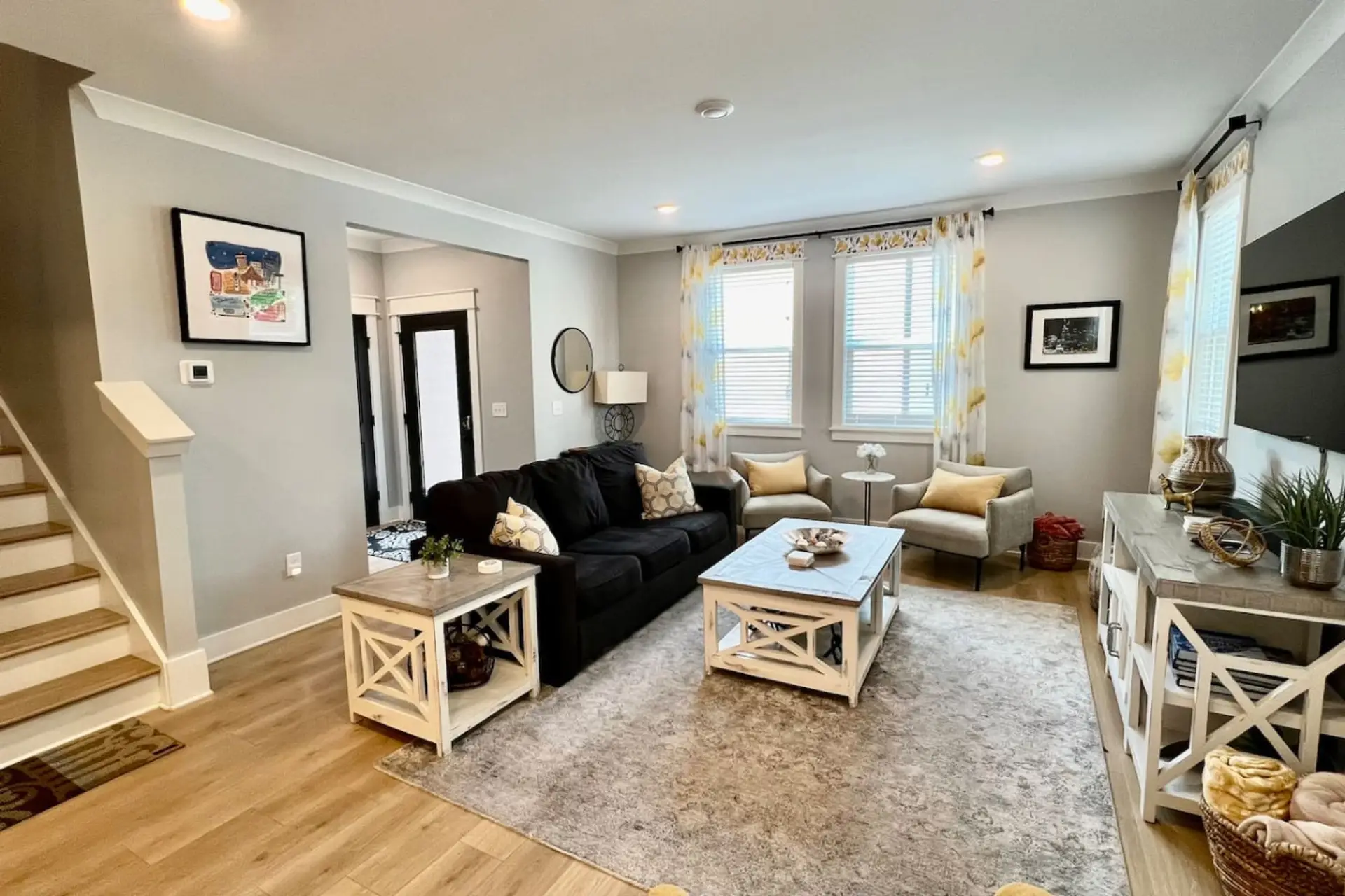 Living room with dark navy sectional sofa, white coffee tables, and large windows