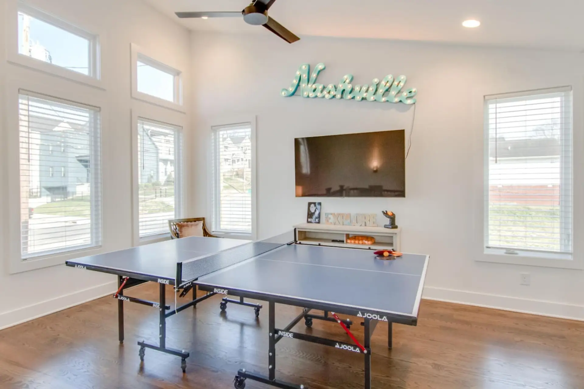 A bright living space with ping pong table and Nashville sign art provides instant vacation energy.