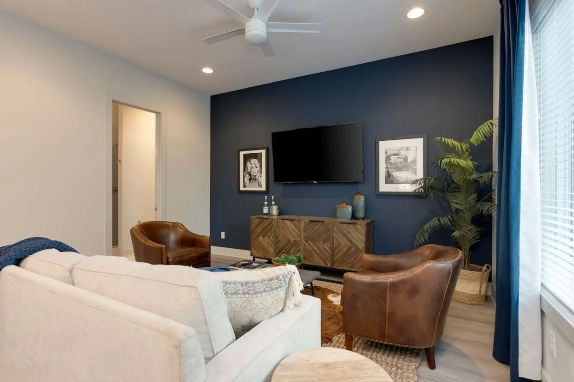 A dark and dramatic living room with a blue TV accent wall is both moody and incredibly inviting.