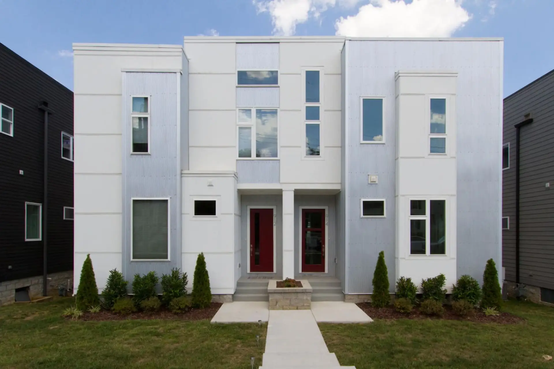 Contemporary townhome facade with sleek architecture and tidy landscaping.