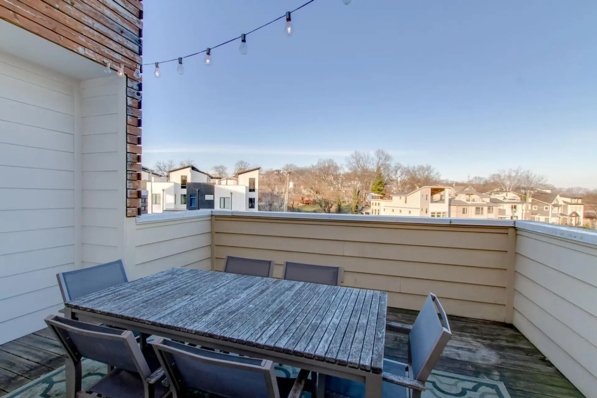 The rooftop terrace is set up with dining tables and string lights for unforgettable Nashville evenings.