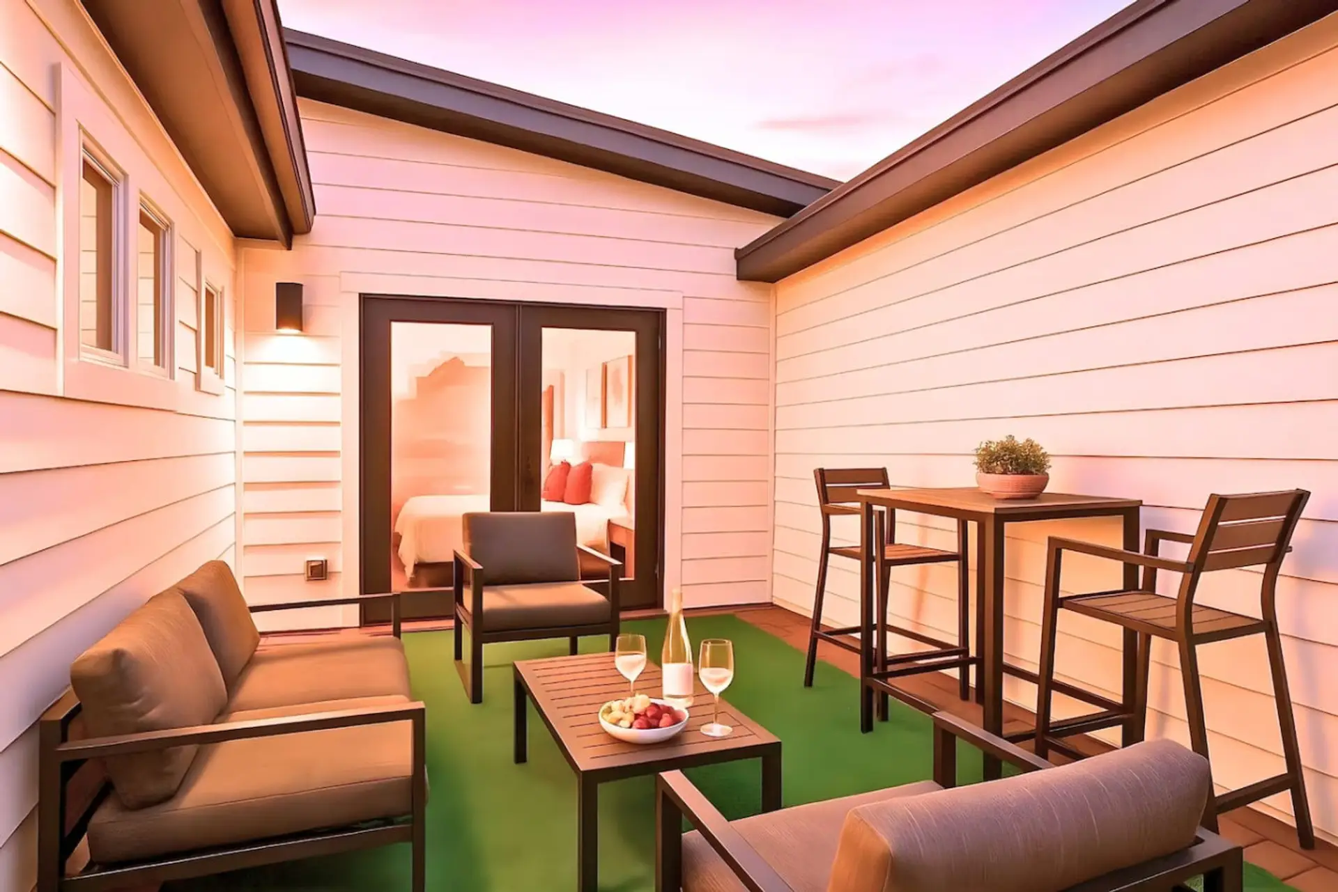 Private rooftop terrace with outdoor seating, dining table, and string lights at sunset