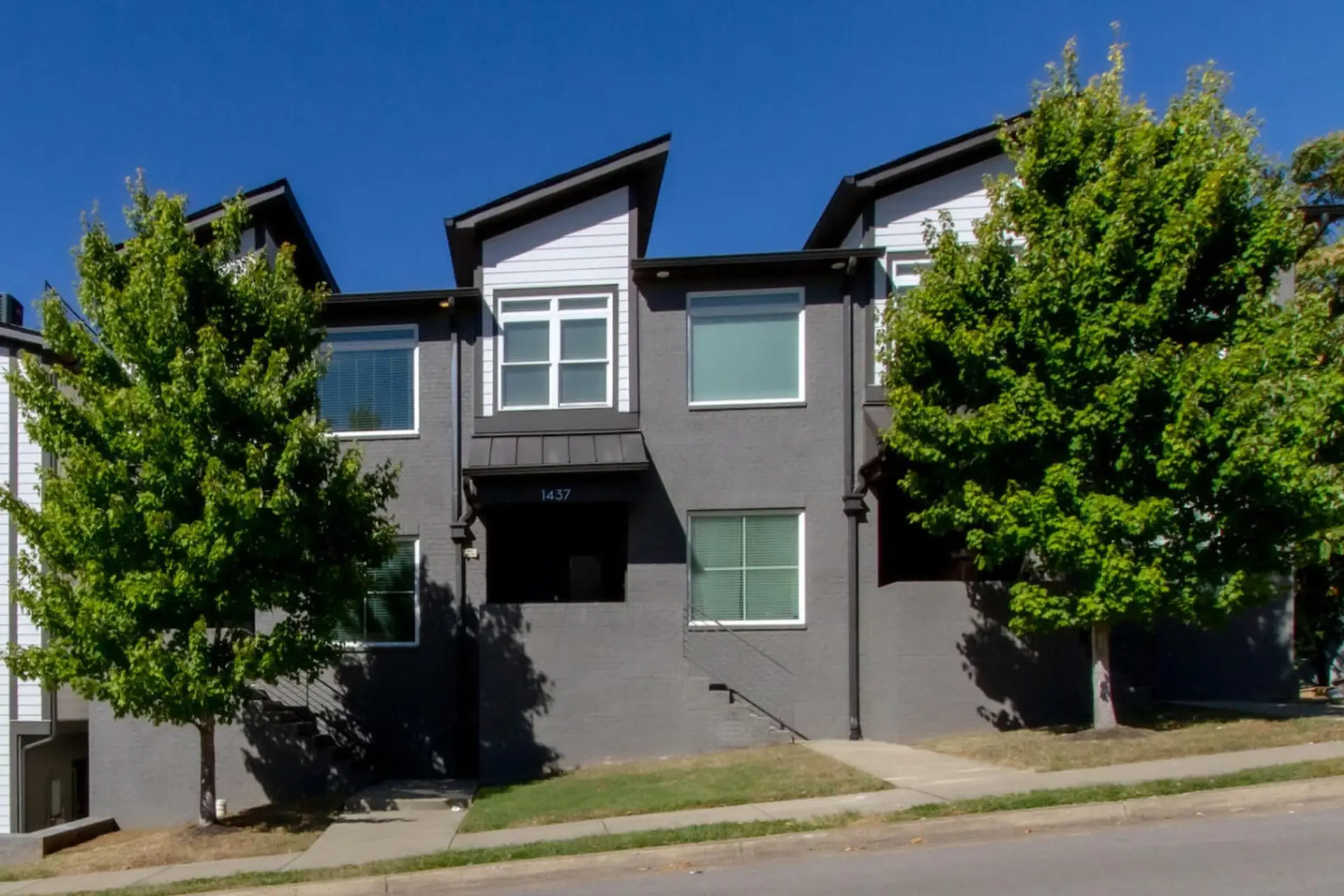 The bold dark exterior with large windows and mature trees makes this 11th Ave home instantly recognizable.