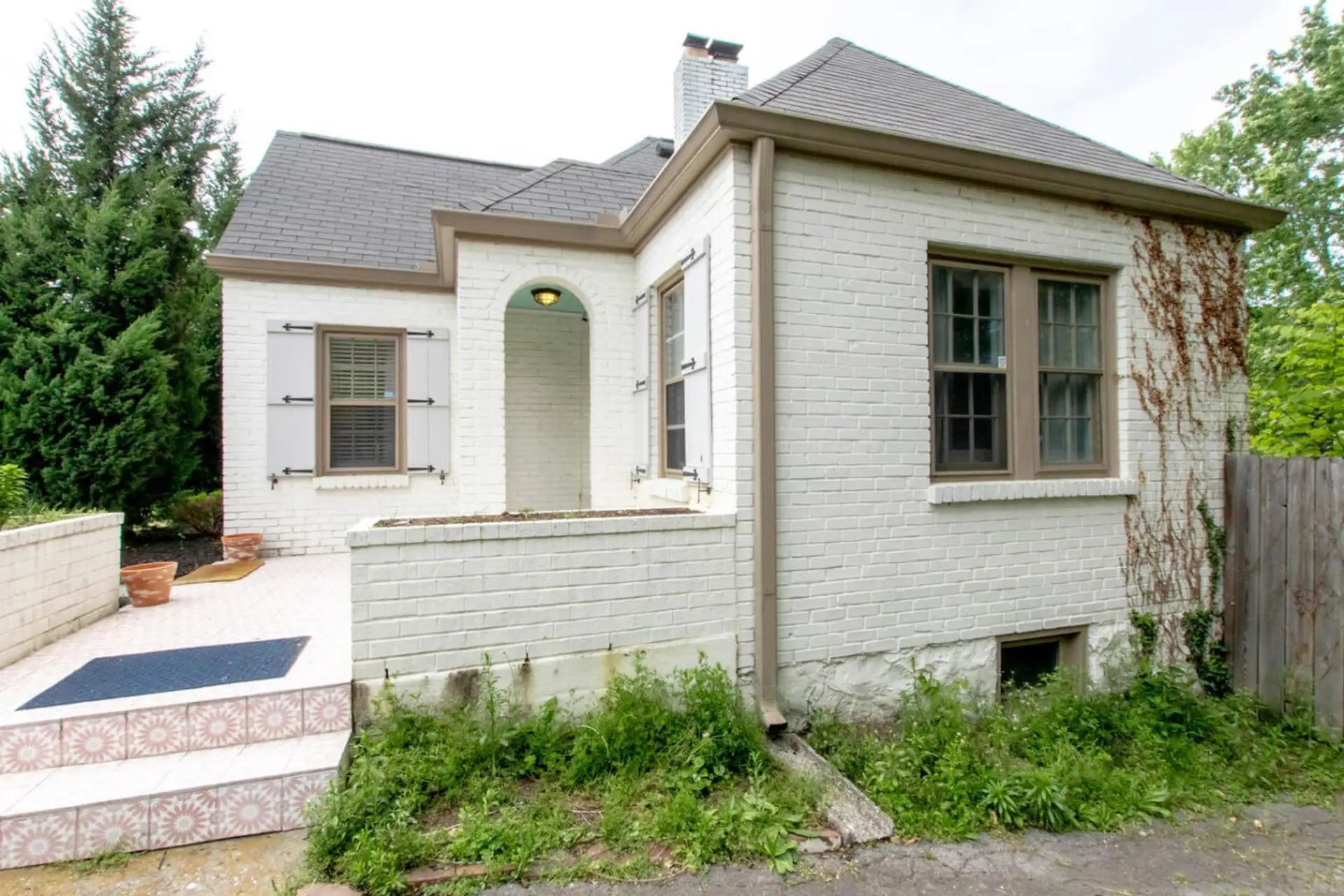 The white brick exterior draped in ivy and framed by mature trees is charming and unforgettable.