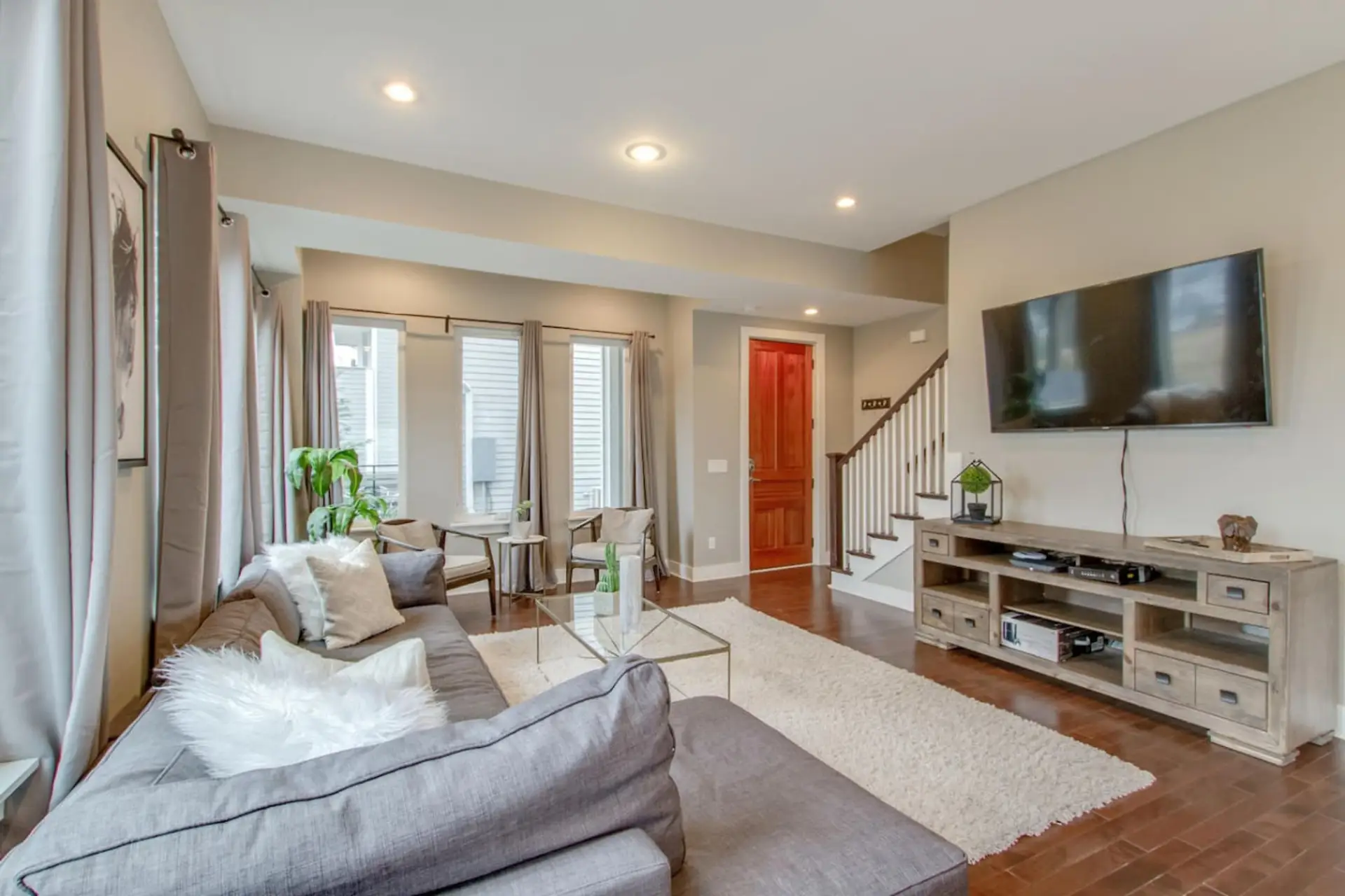 The open and bright living space with plenty of seating and a red accent door is a welcoming group retreat.