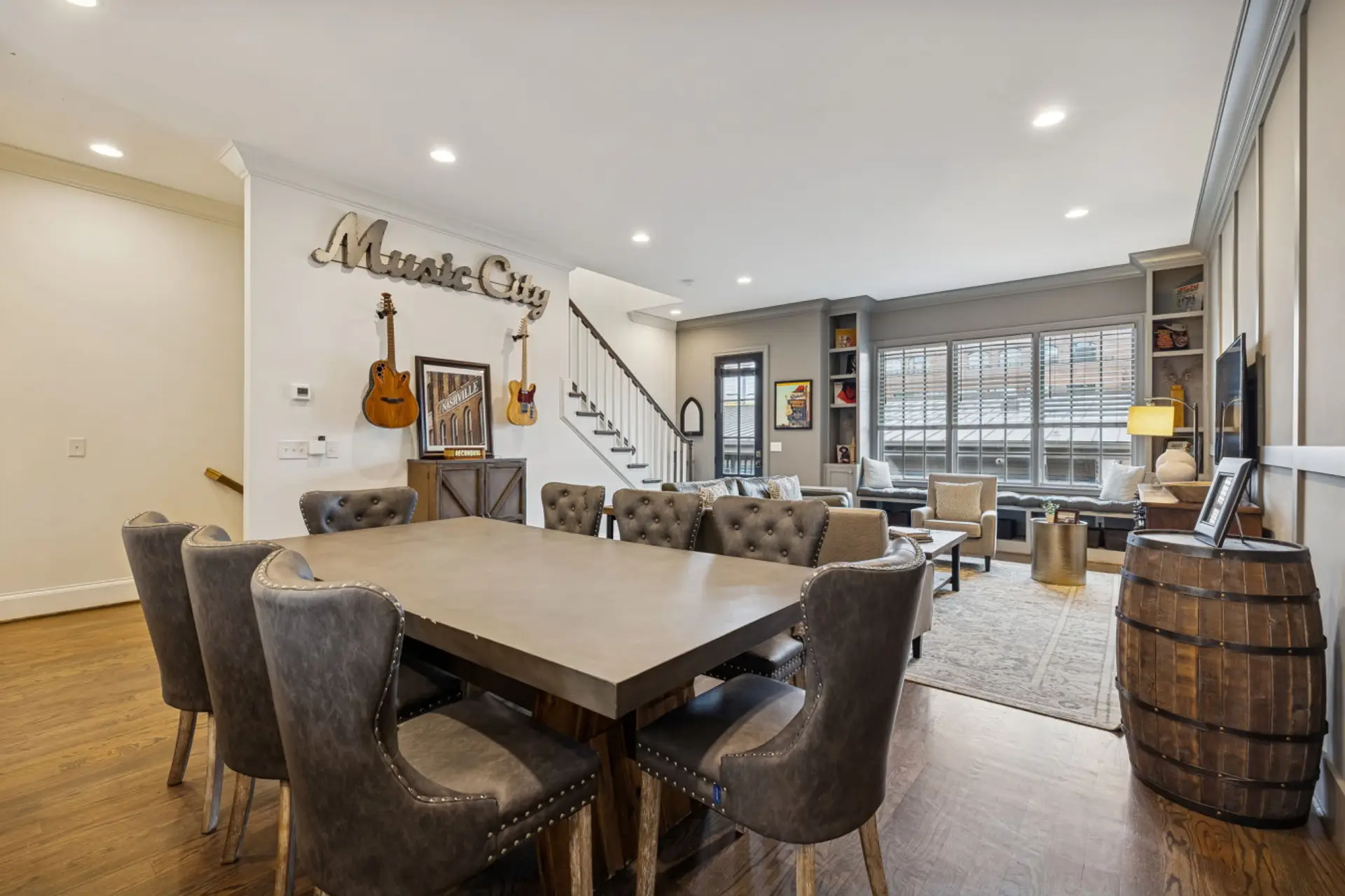 The open main floor features a Music City sign, dining table, and comfortable seating for the whole group.