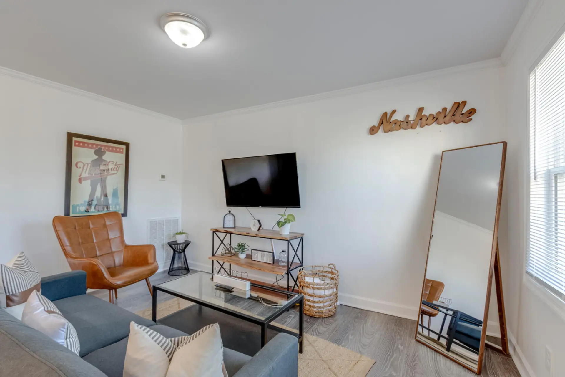 Living room with flatscreen TV, Nashville sign and floor mirror