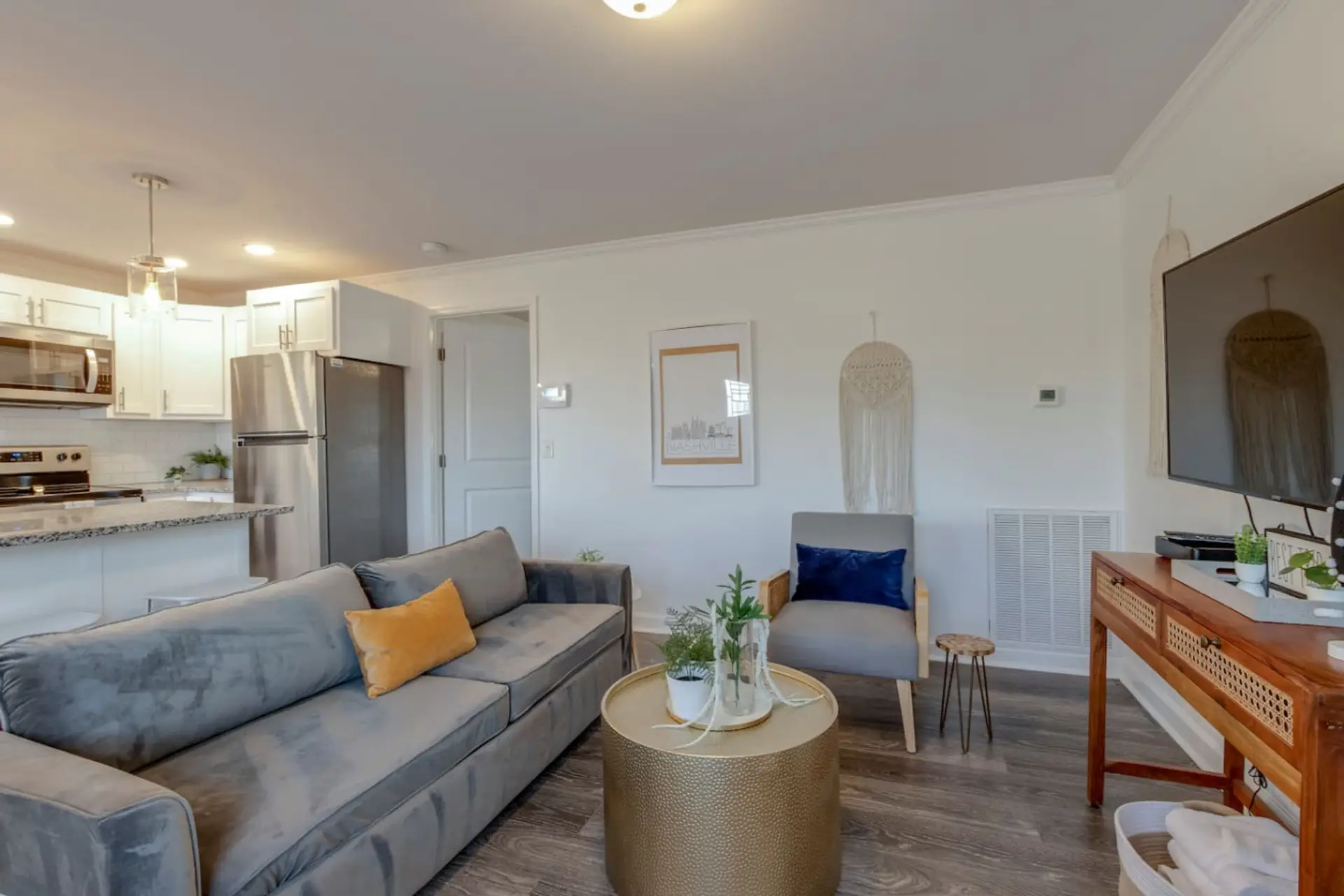 Open living area with a comfortable sofa and kitchen visible in the background