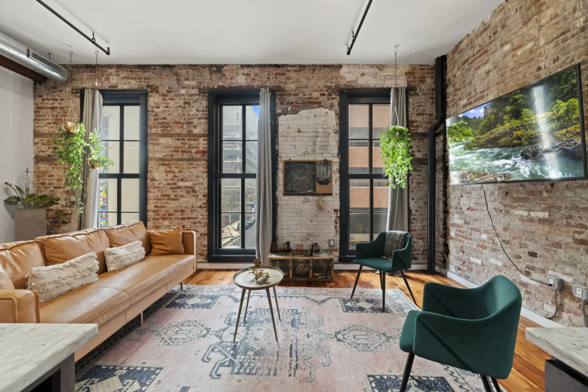 Cozy seating area featuring large windows, natural light, and a newly installed smart TV.