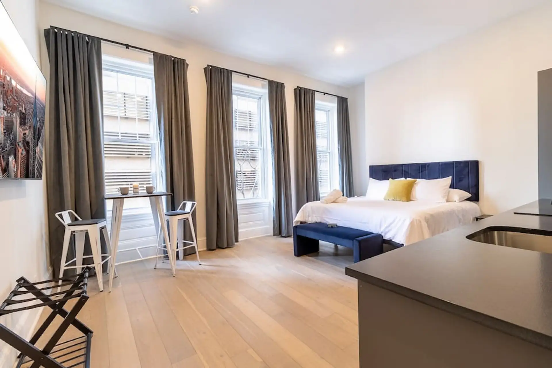 Spacious king bedroom with dining nook and large windows.