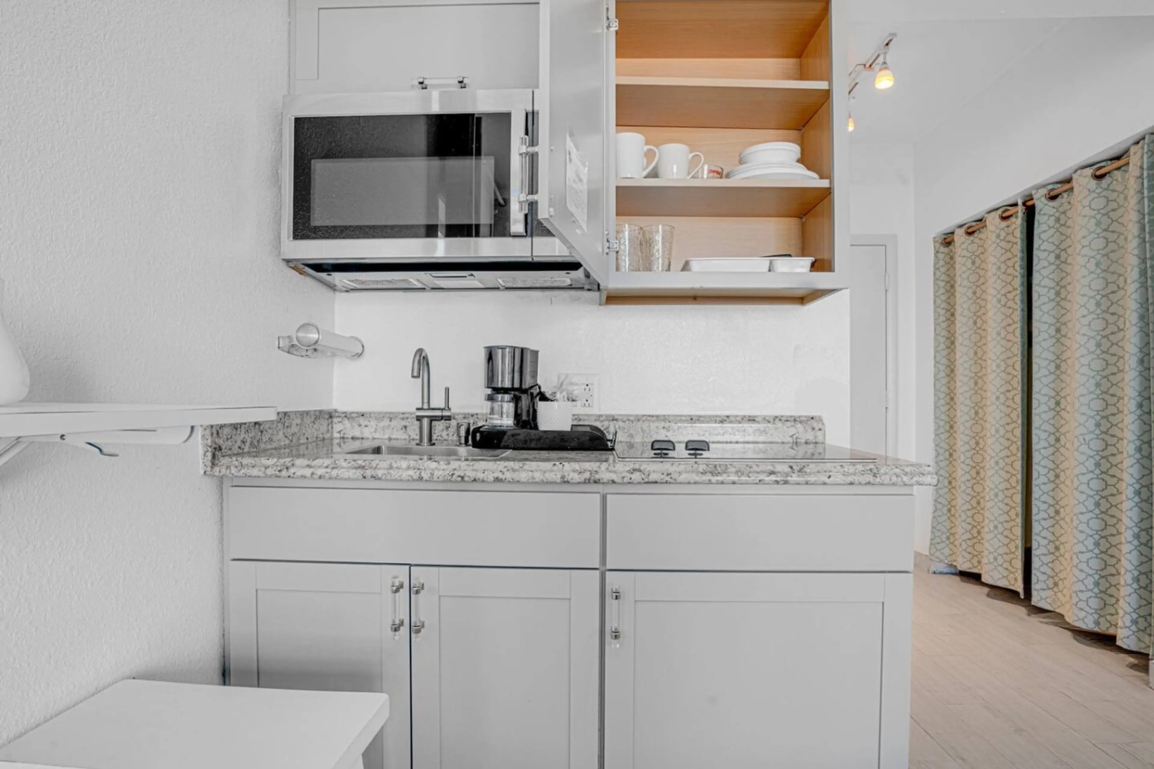 Efficiency meets elegance in our petite kitchenette, perfect for culinary adventures.