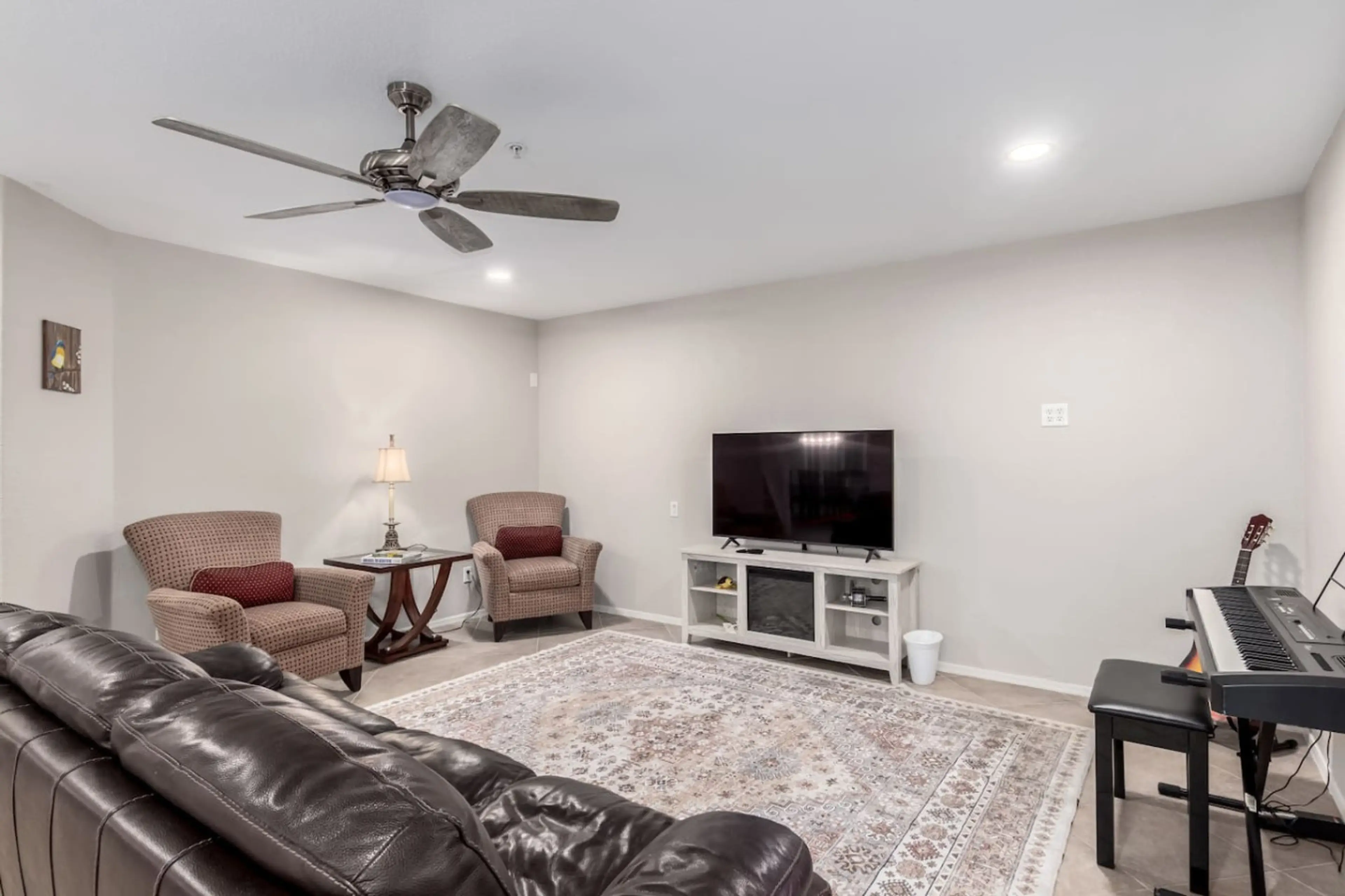 Living room with Smart TV, guitar, and keyboard for entertainment