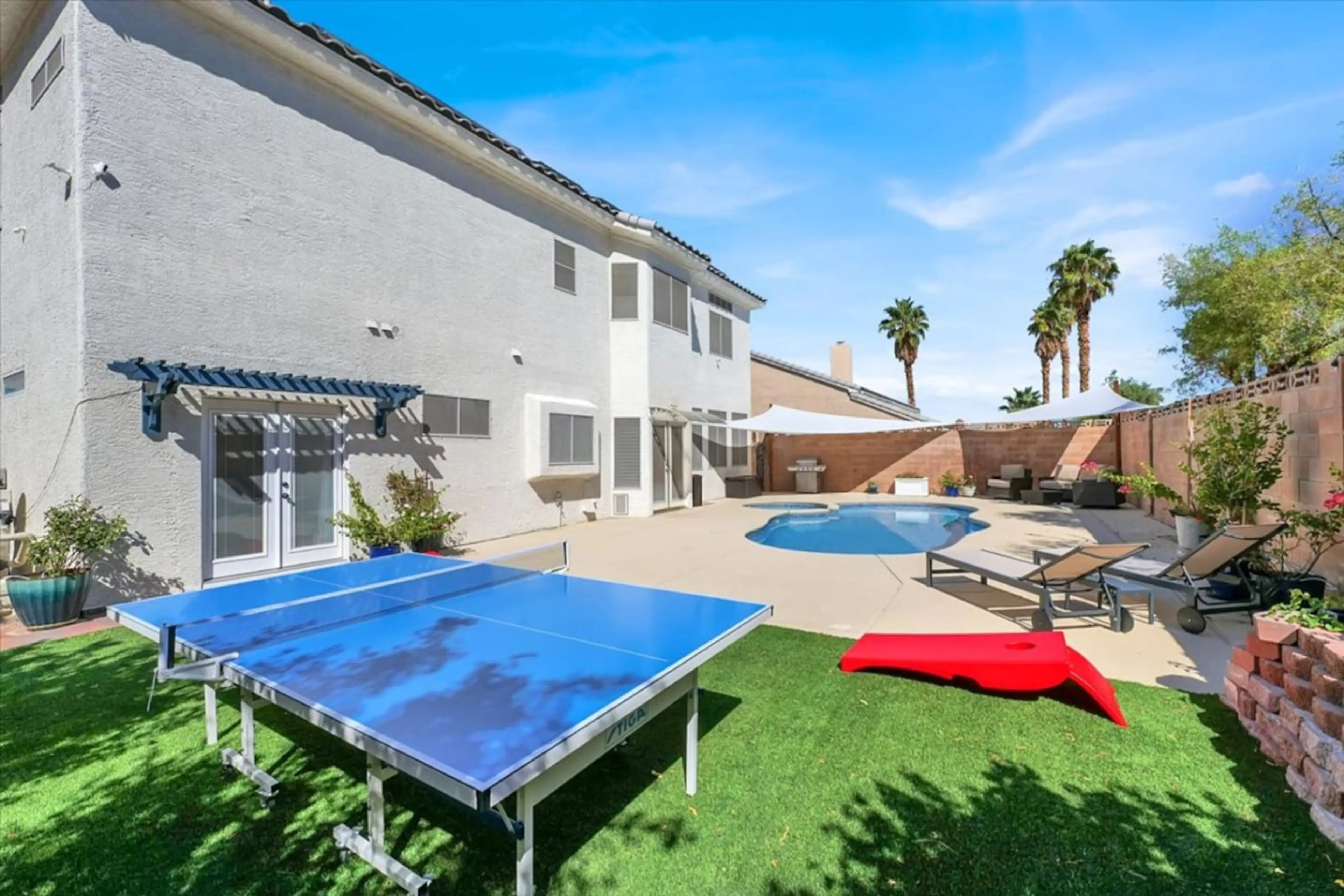 Enjoy a private backyard oasis with a sparkling pool, lounge seating, and plenty of space to relax or entertain.