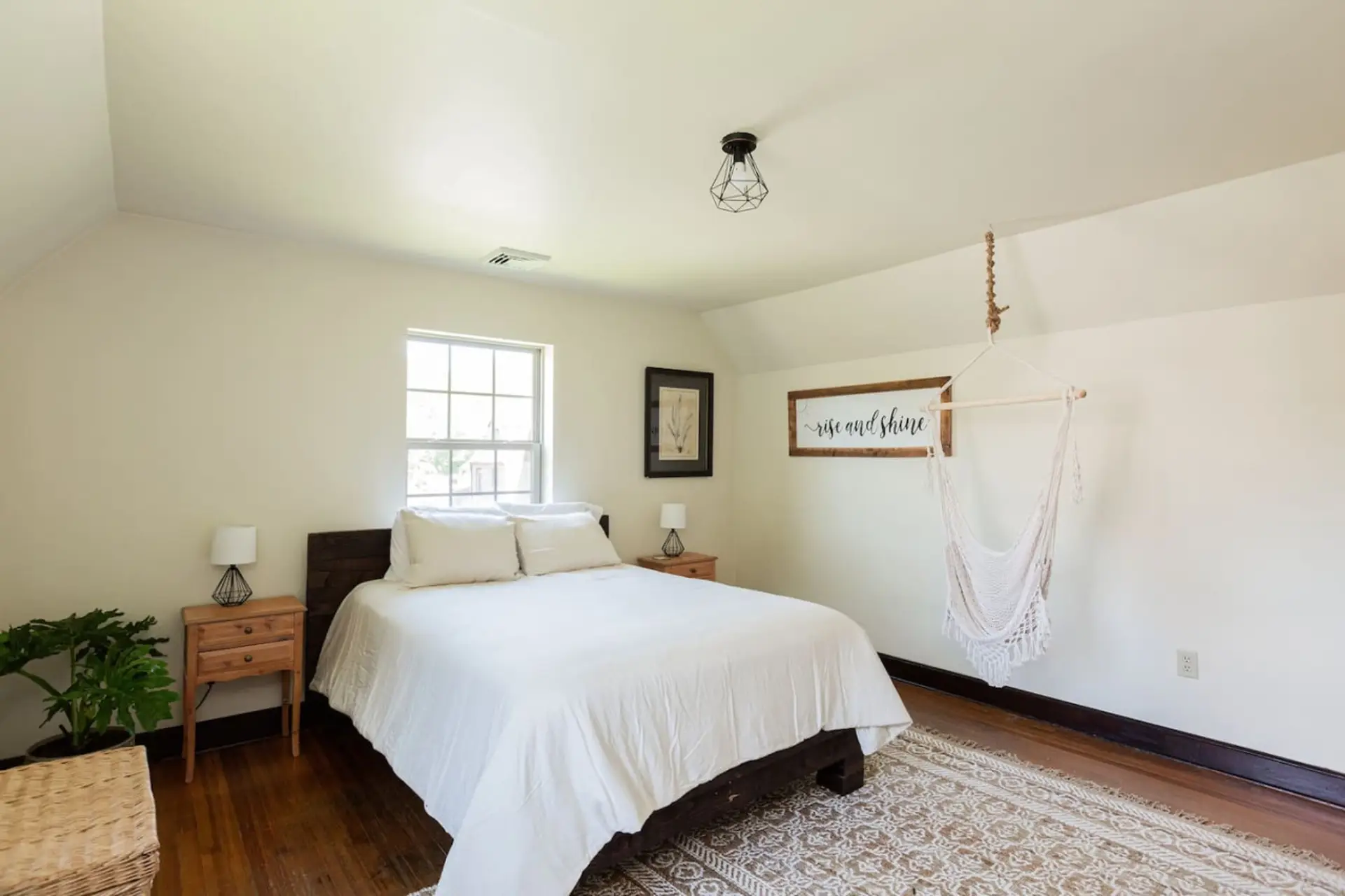 Minimalist bedroom with white bedding, wood floors, bedside tables