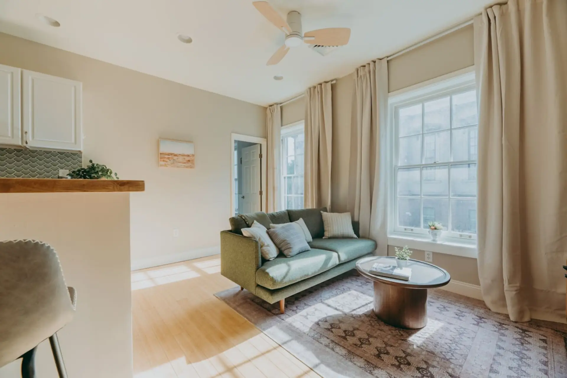 Minimalist living room with sofa, ceiling fan and large window