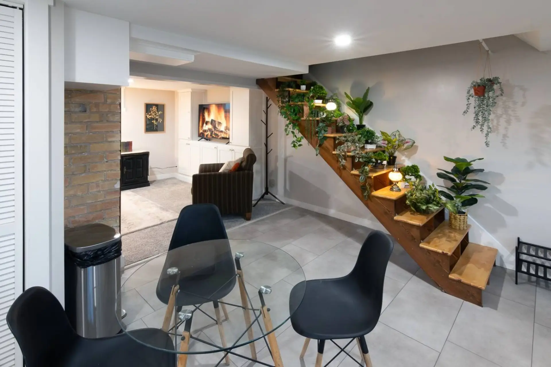 Full kitchen / Dining area with sink, full-size refrigerator, toaster oven, microwave, full-size oven, range, coffee pot, and electric tea kettle. Welcoming green decor lines the staircase