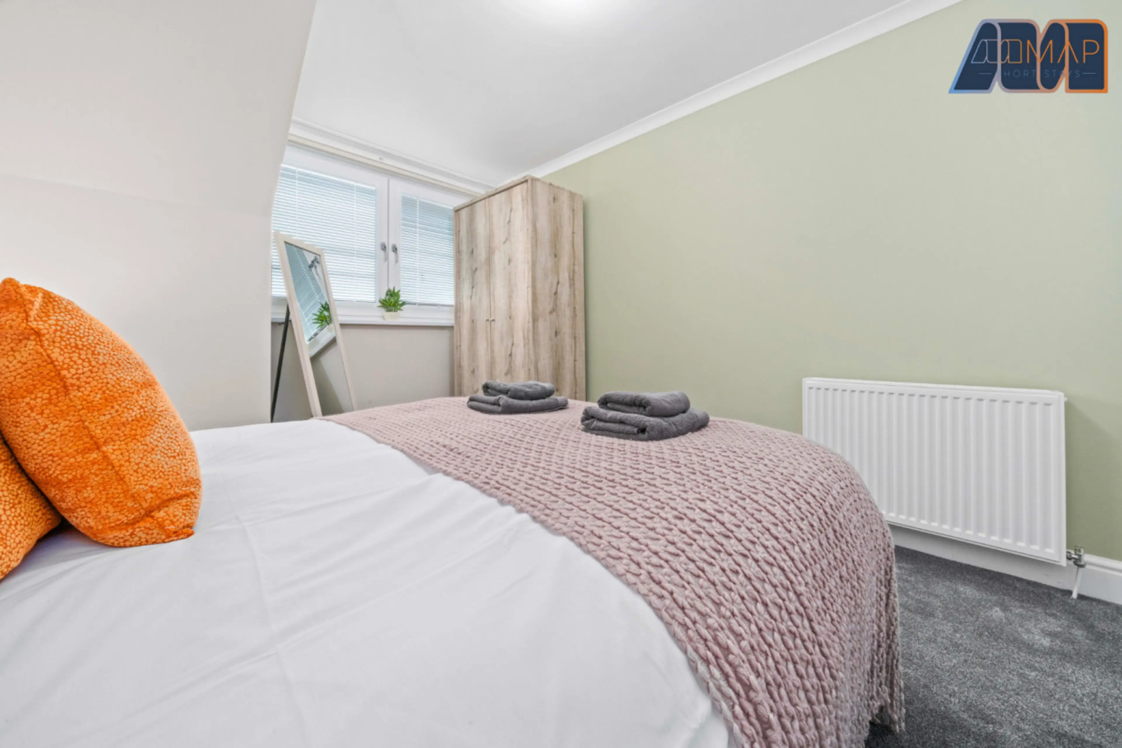 Comfortable bedroom with fresh towels and plush pillows for a restful stay.