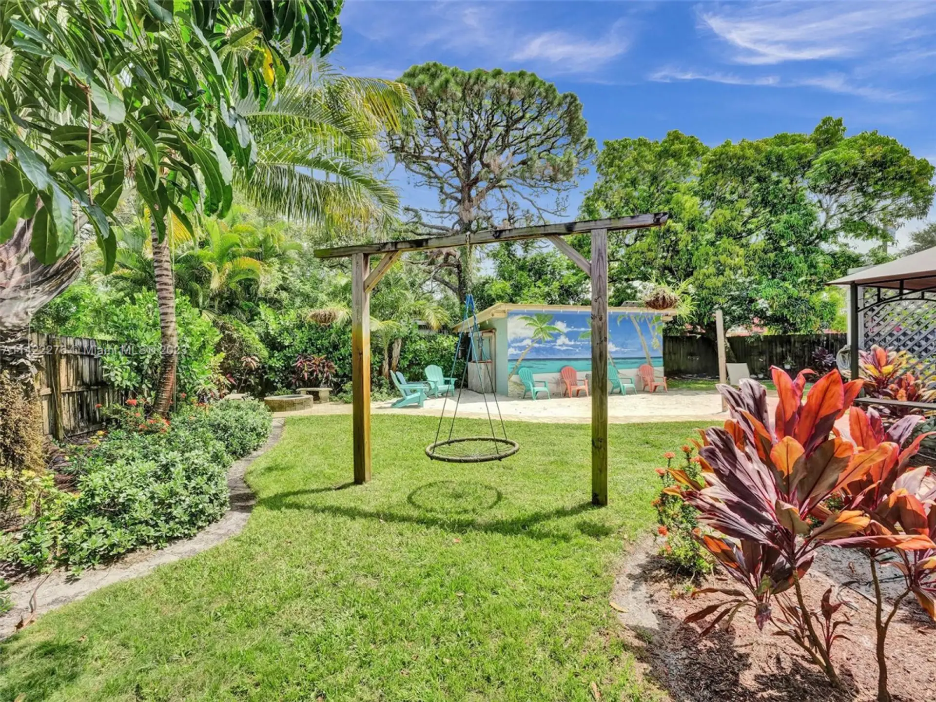 Outdoor dining table on the deck with a view of the backyard "beach" oasis, perfect for alfresco meals and relaxation.