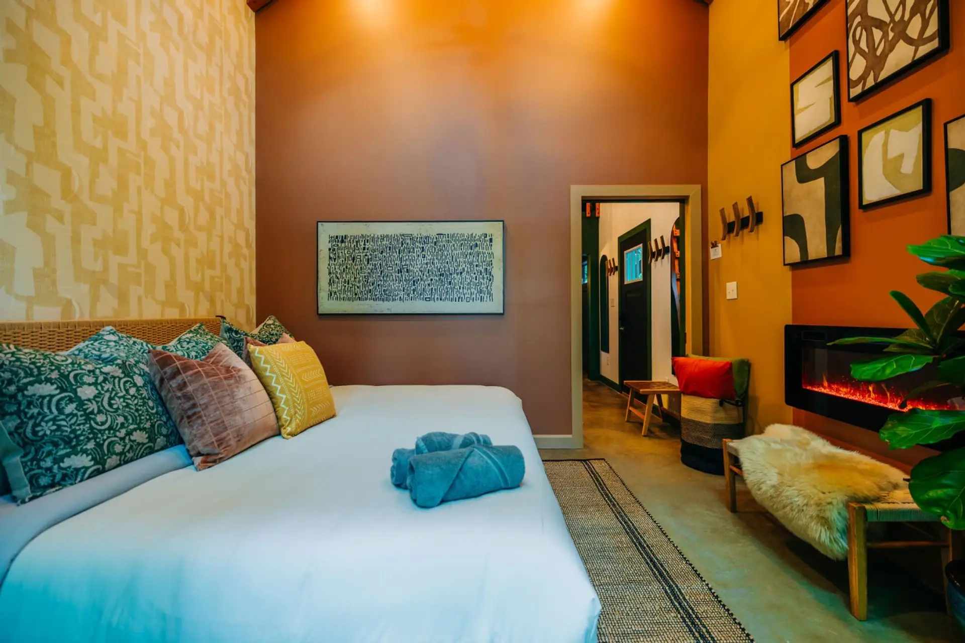 Soft bedding, warm art, and a glowing fireplace create an intimate bedroom for your romantic Red River Gorge escape.