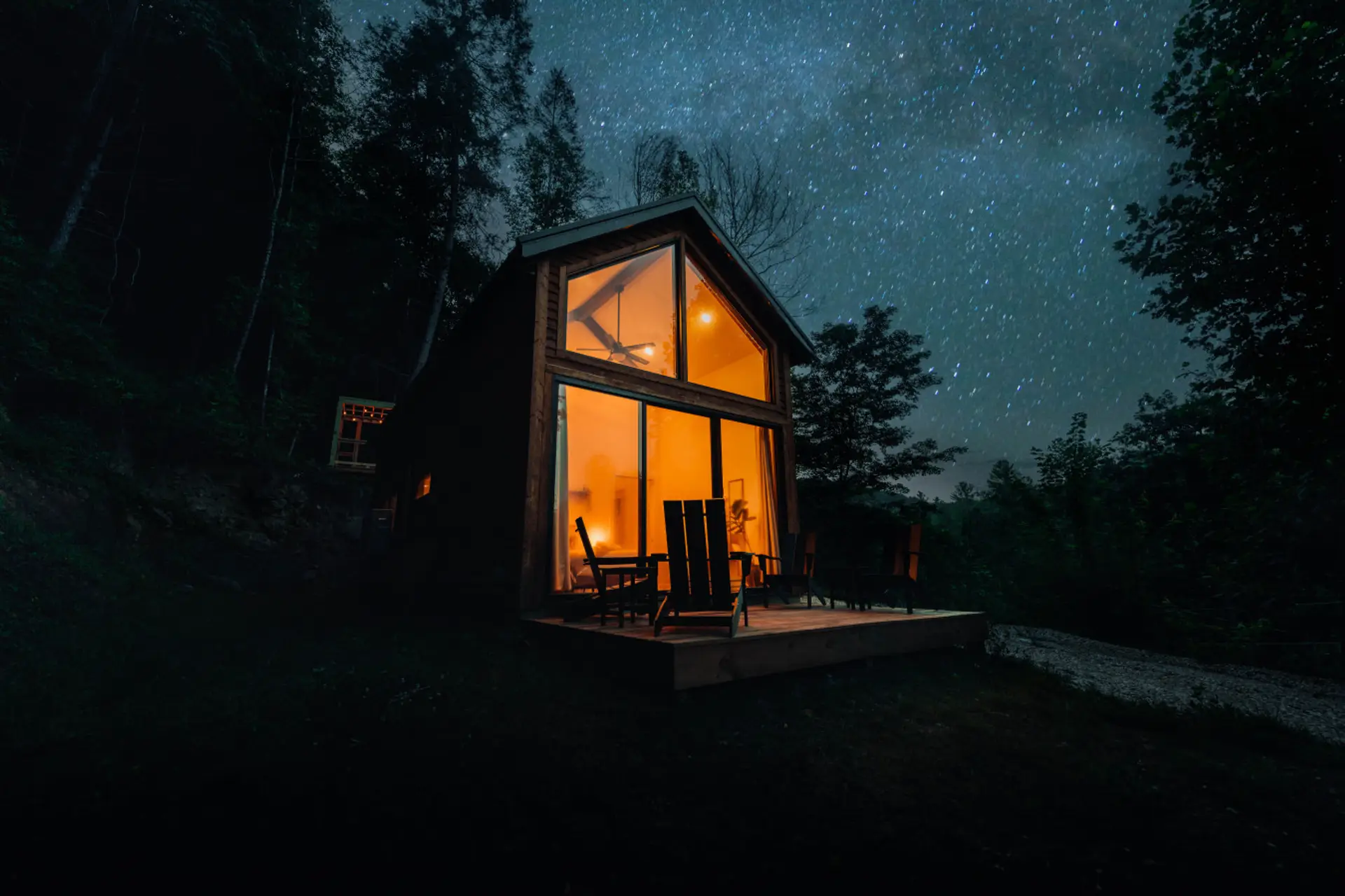Stargaze beside a glowing cozy cabin, where quiet forest nights feel made for romantic mountain escapes