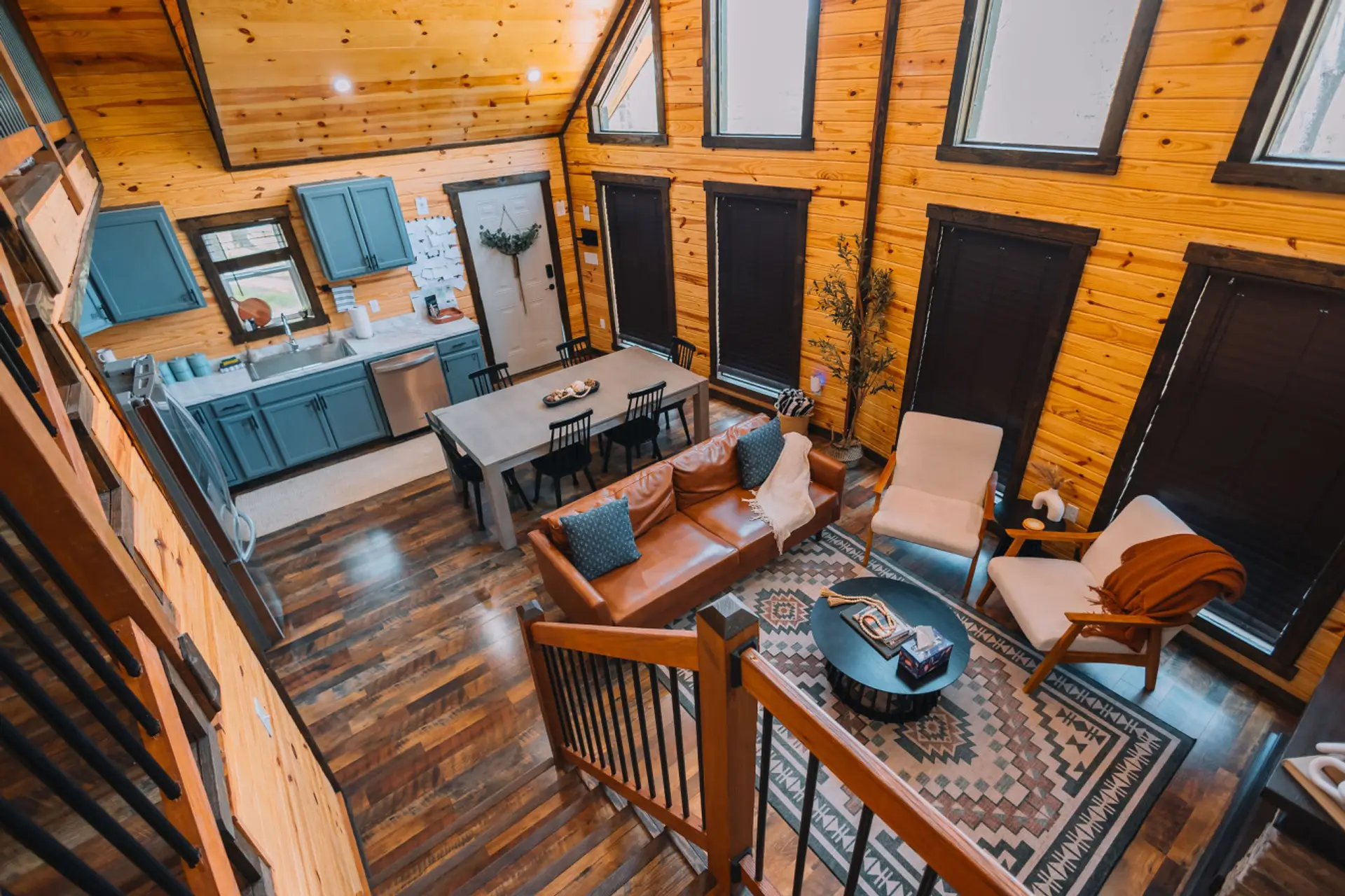 A look from the stairs down to the living room, dining area, and kitchen