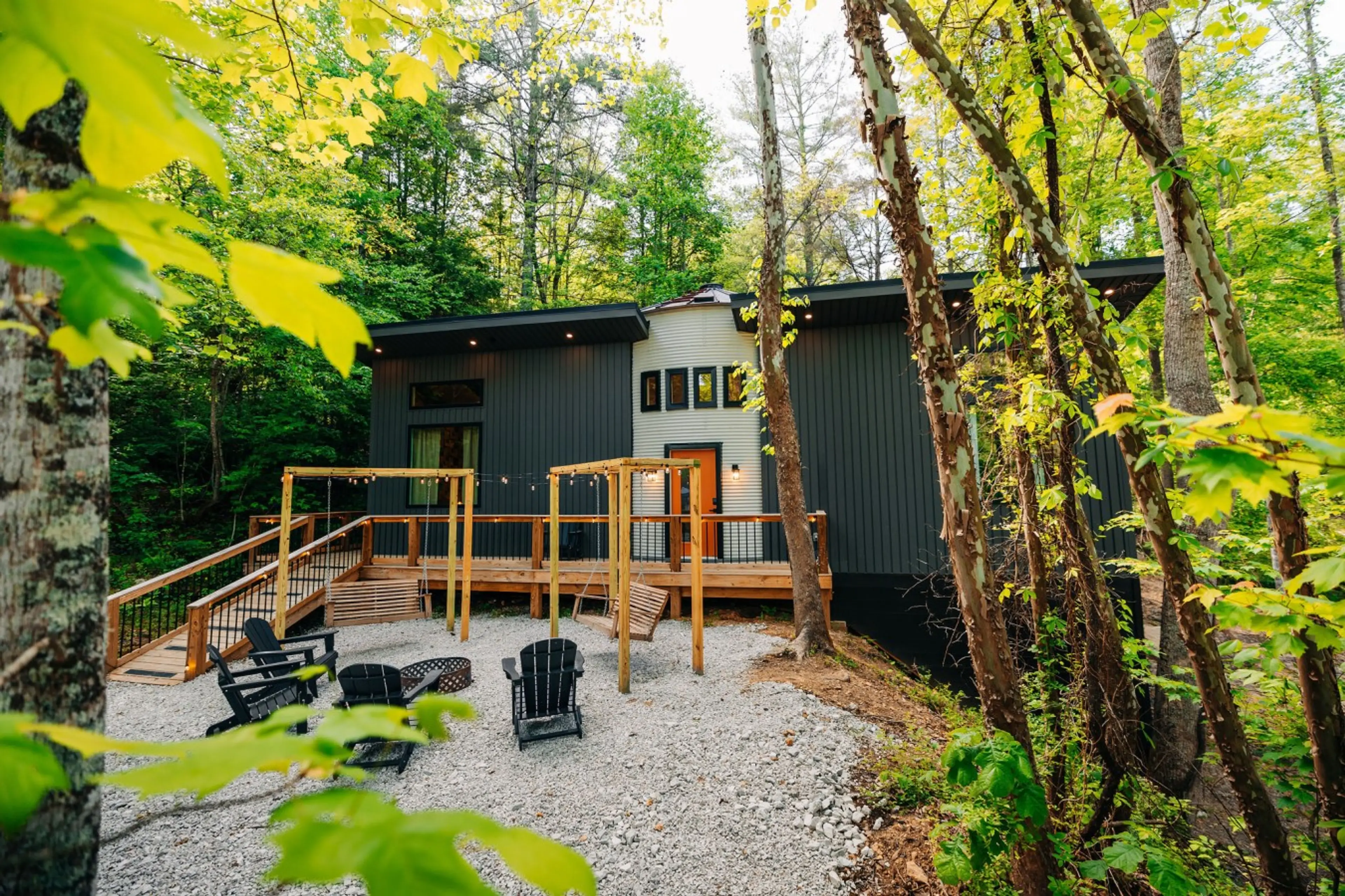 Modern forest cabin with deck swings and fire pit seating for memorable family vacations and friends trips