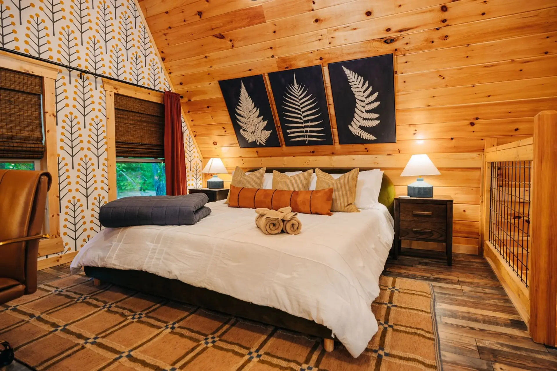 Warm wood bedroom with layered pillows, soft linens, and forest-inspired decor for restful cabin nights