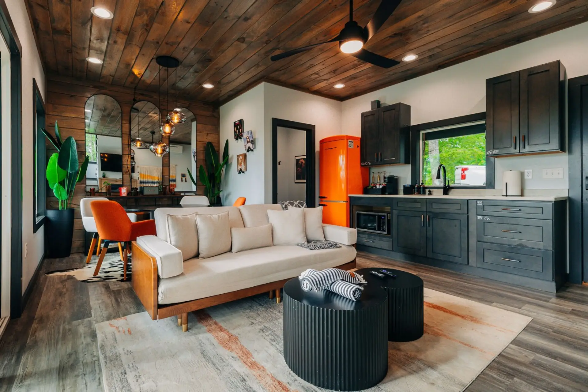 Bright open living space with compact kitchen comforts, cozy seating, and playful modern cabin style
