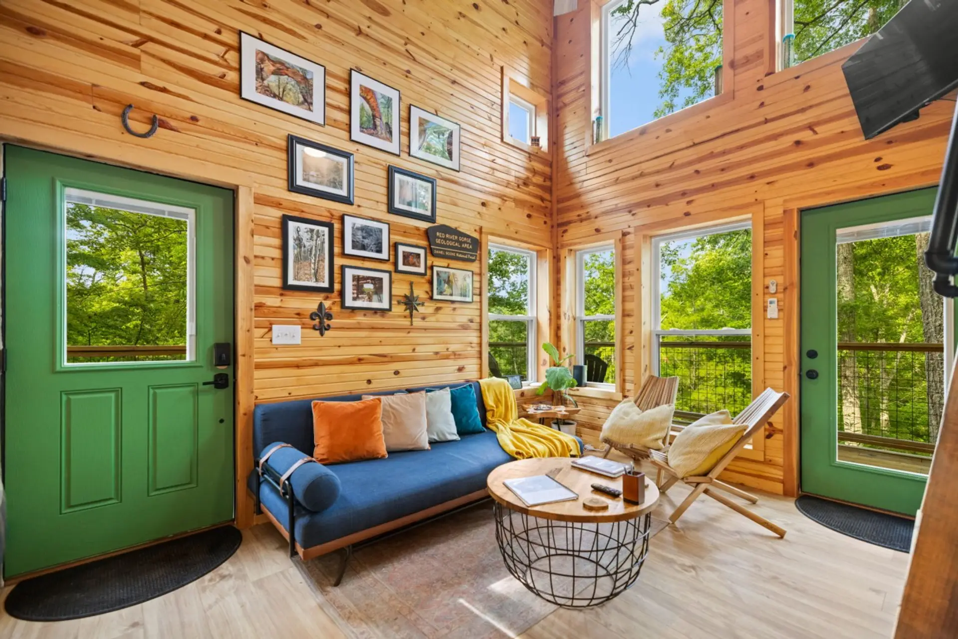 Warm wood, tall windows, and soft light — a quiet cabin living room made for two after a day on the trails.