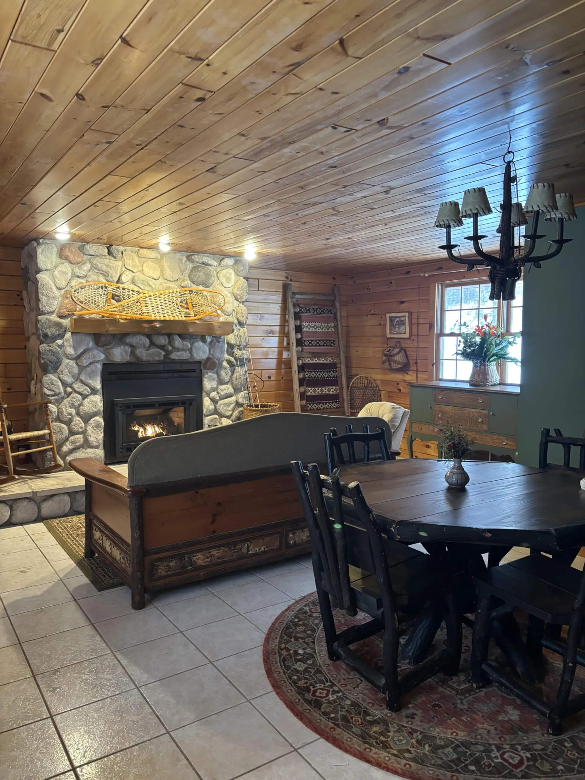 Warm living area featuring an Adirondack-style fireplace surrounded by natural wood