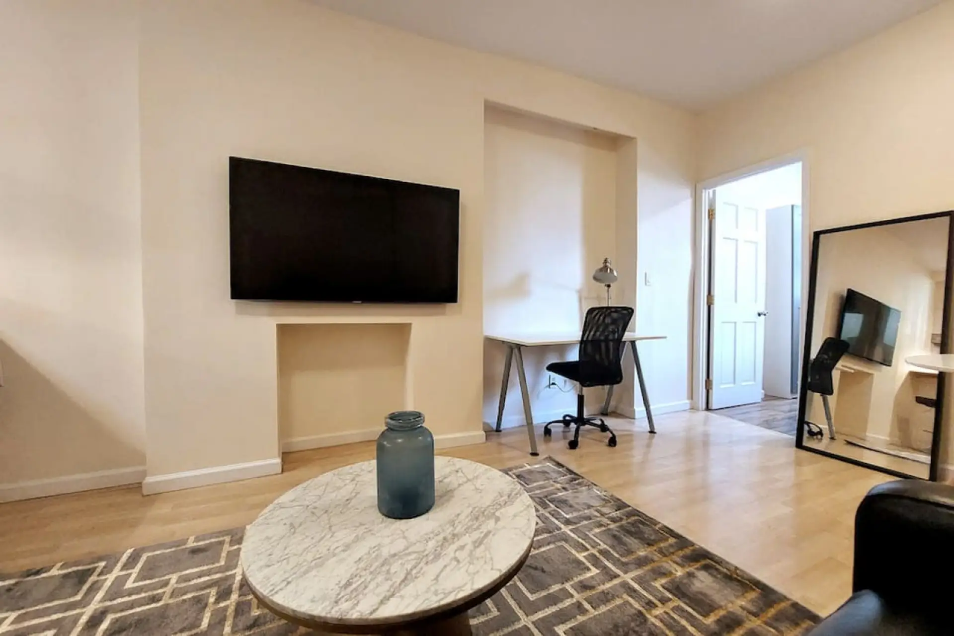 Living room has a leather couch with pull out, full size bed, 55'' flat screen TV, workstation, and dinning area