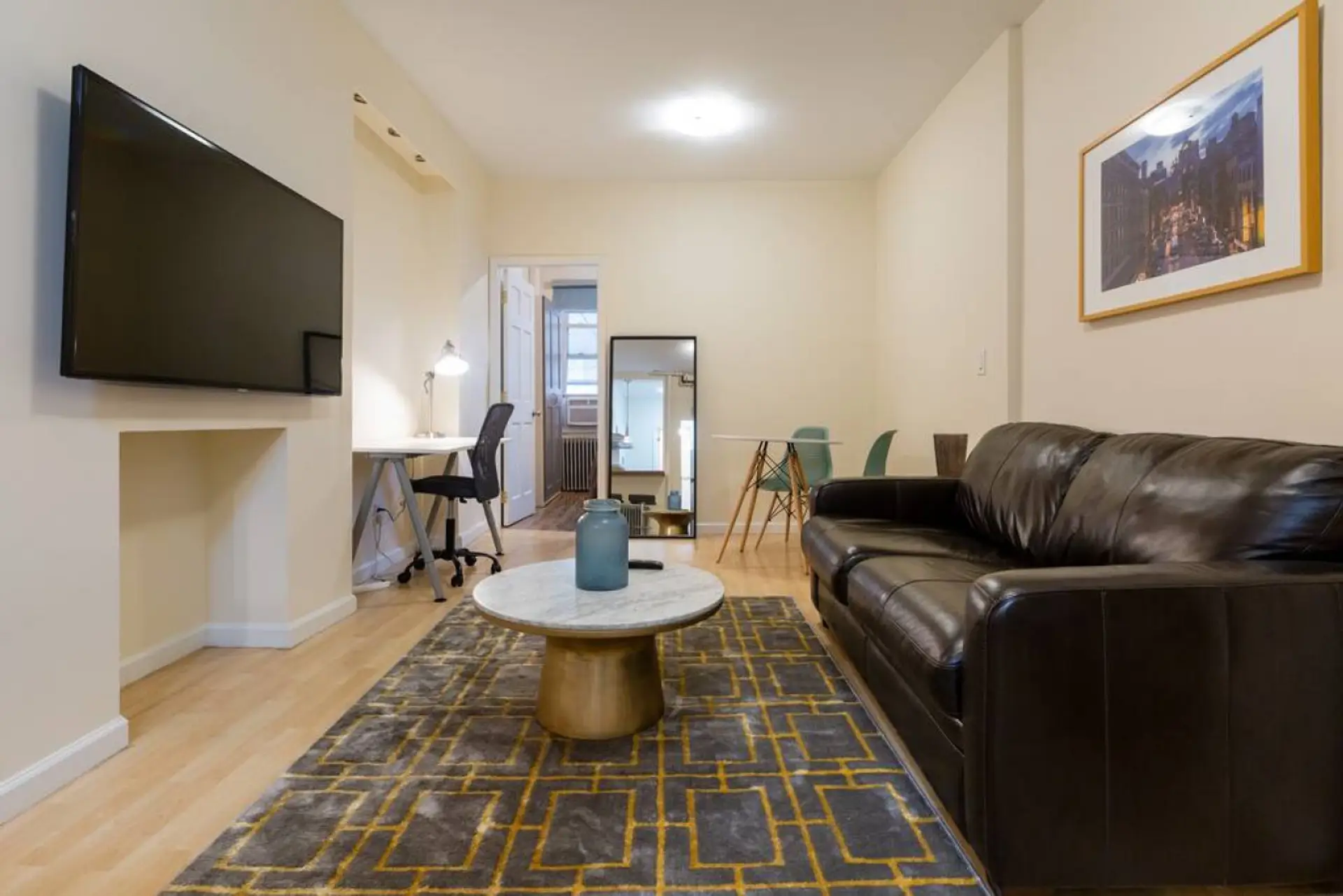 Living room has a leather couch with pull out, full size bed, 55'' flat screen TV, workstation, and dinning area.